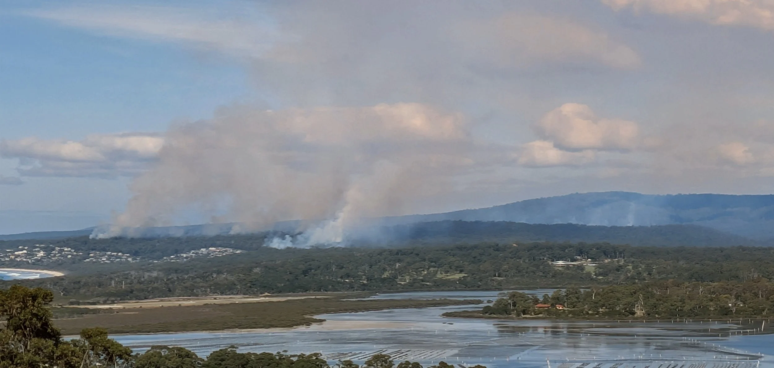 Multiple smoke columns rising from coordinated planned burns in the Far South Coast bushland, demonstrating tactical hazard reduction analyzed via the FiSci Mitigate AI platform.