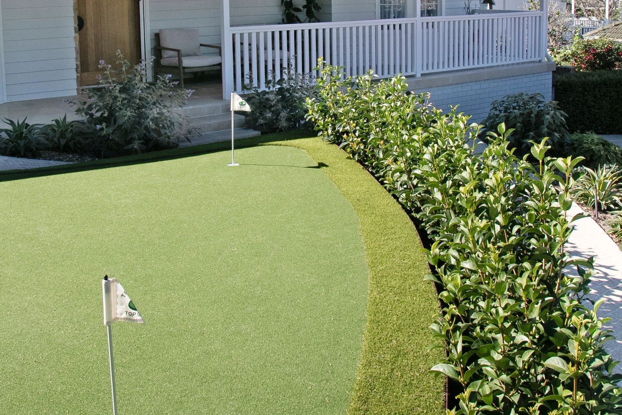 Raised three-hole putting green in front of the porch of a Yowie Bay home
