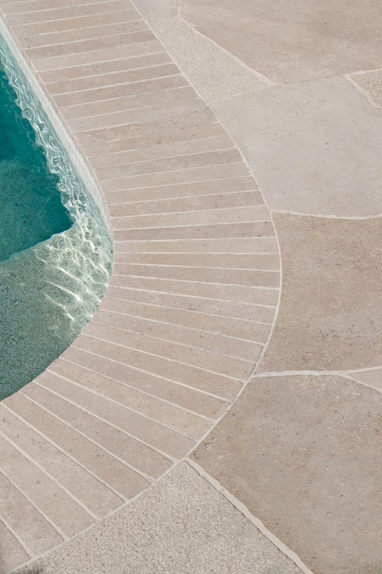 Curved stone coping and paving around the pool's splash zone in Yowie Bay