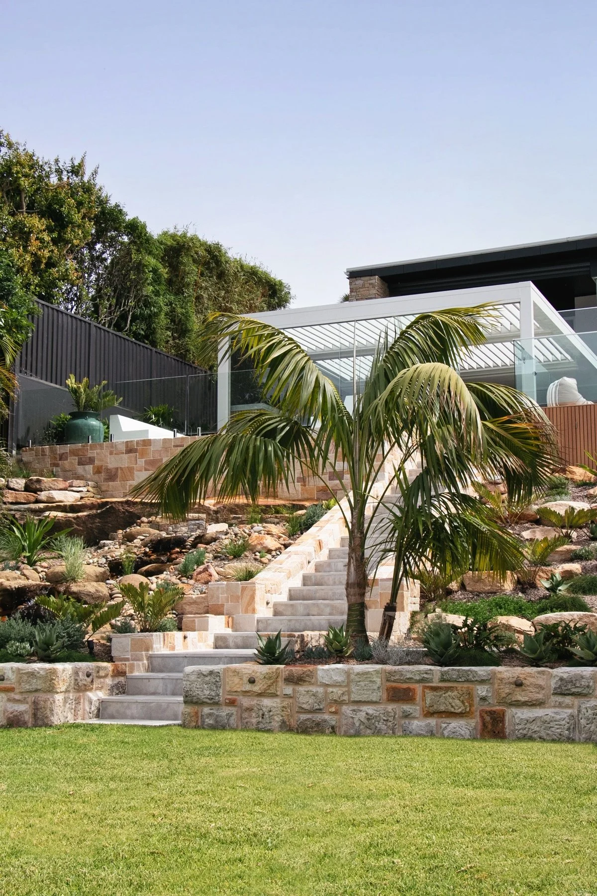 Sandstone retaining walls and grand staircase landscaping project in Sutherland Shire backyard