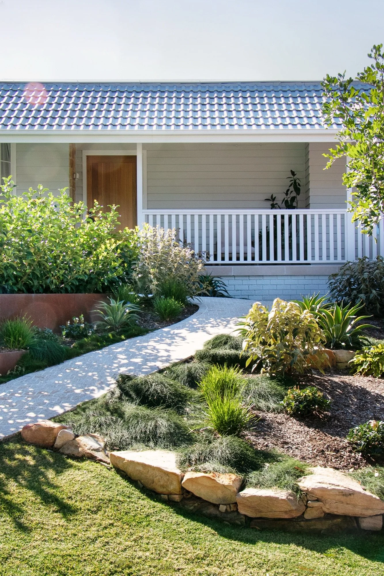 Winding path through tiered mass planting to the front porch of a Yowie Bay home