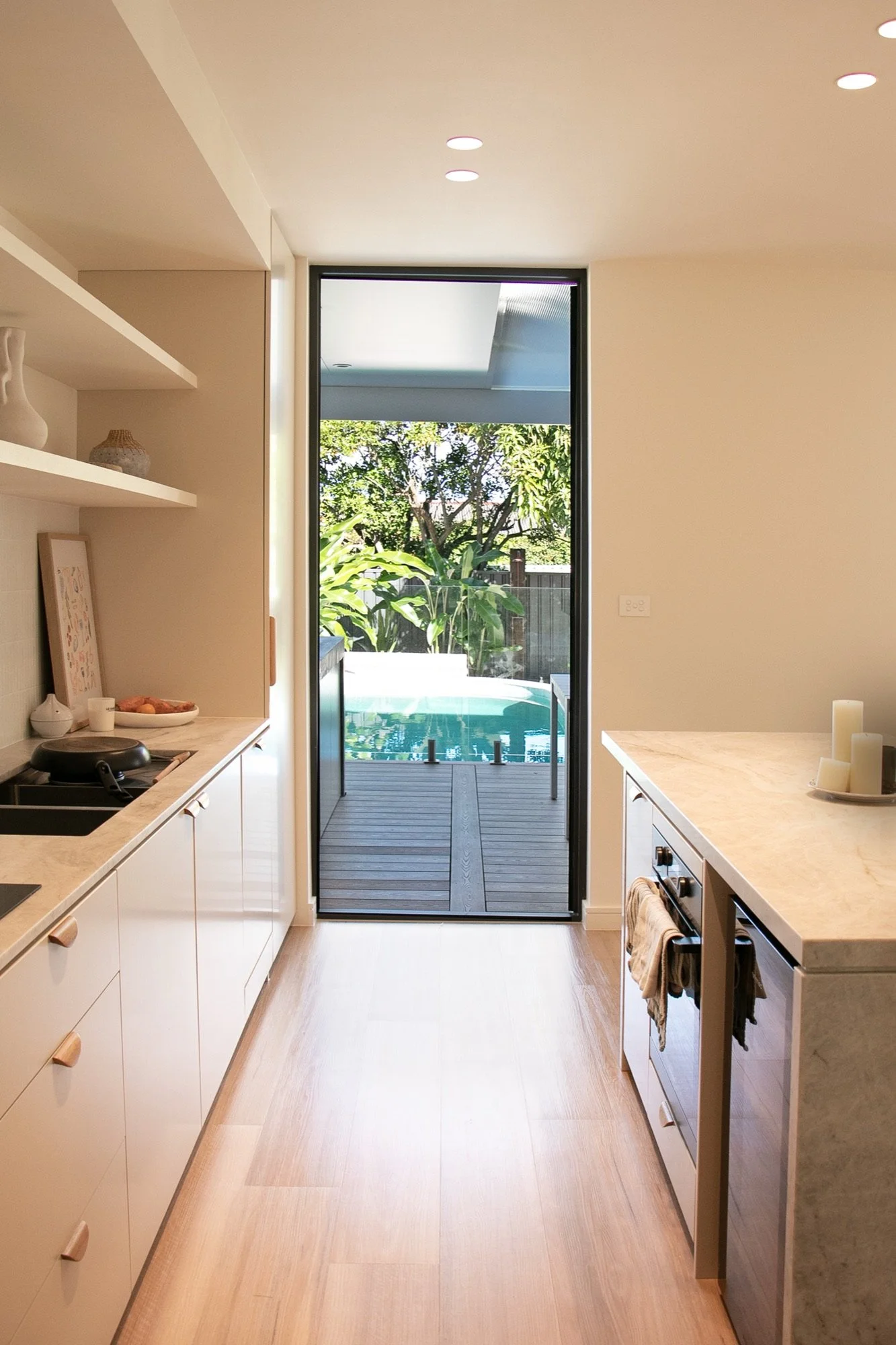Renovated galley kitchen looking straight out to the deck and pool in Chifley
