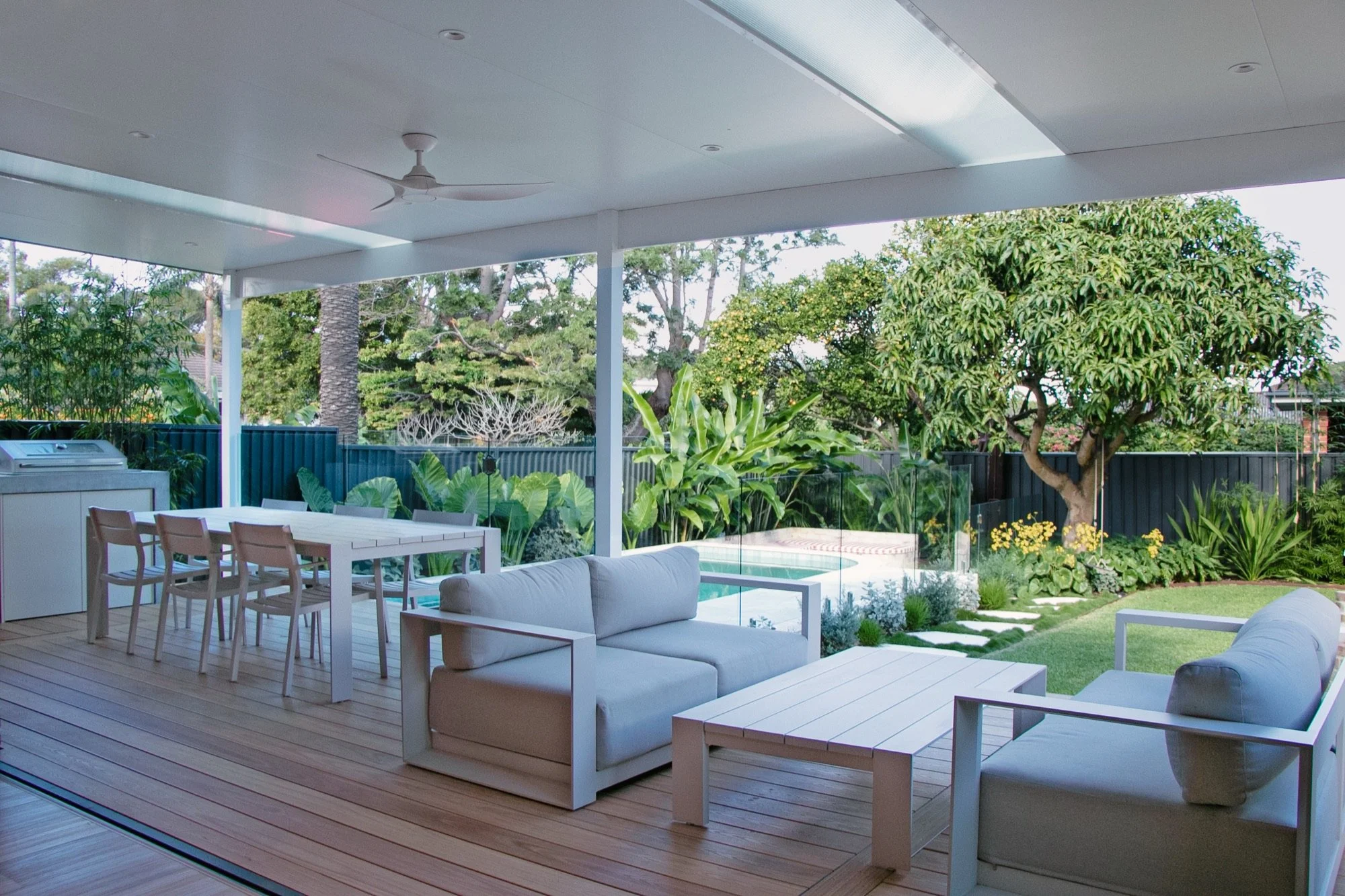 Full-width entertaining pergola with lounge, dining and timber deck overlooking the garden in Chifley