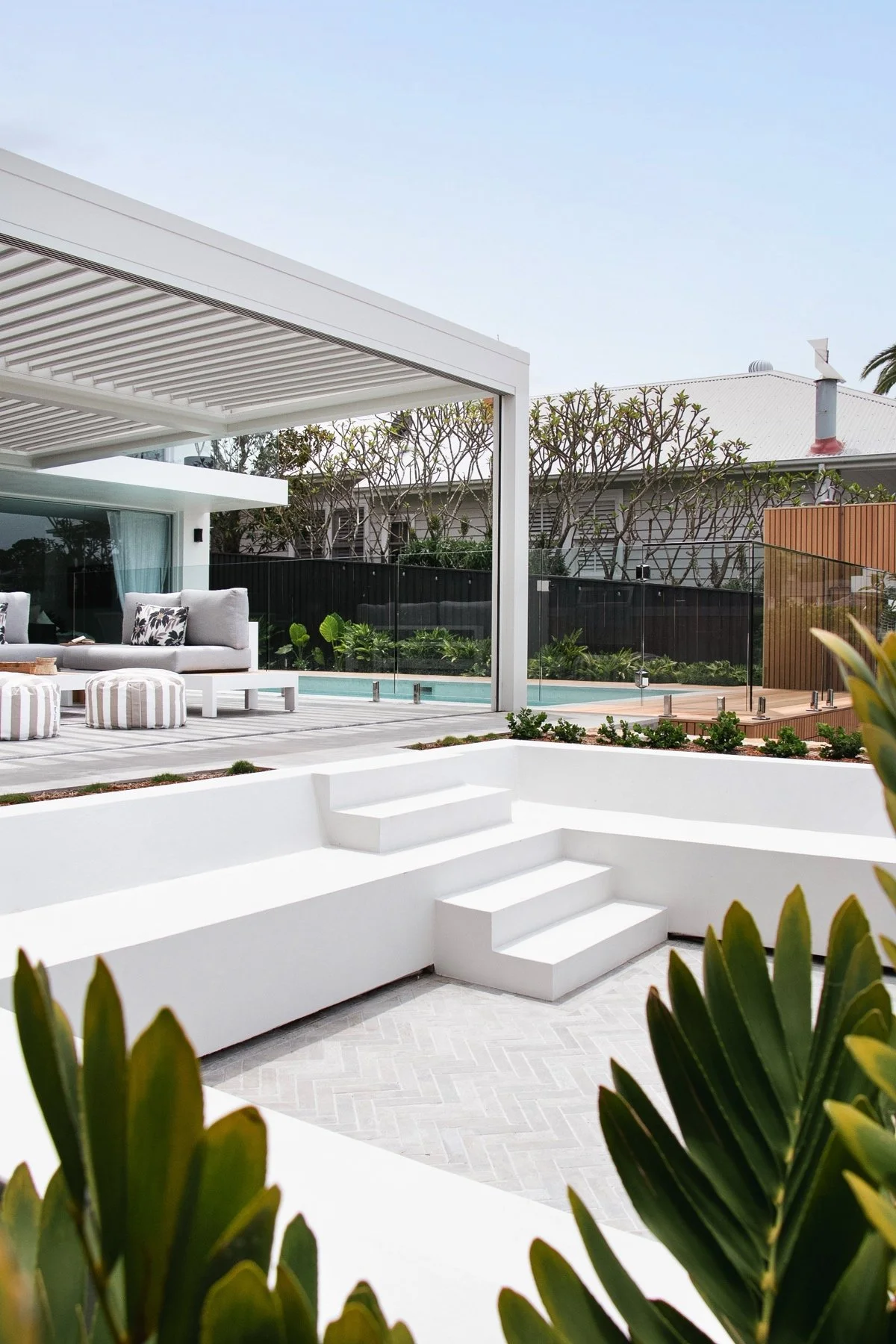 Tiered outdoor living area with custom concrete seating and pool renovation, Sutherland Shire NSW