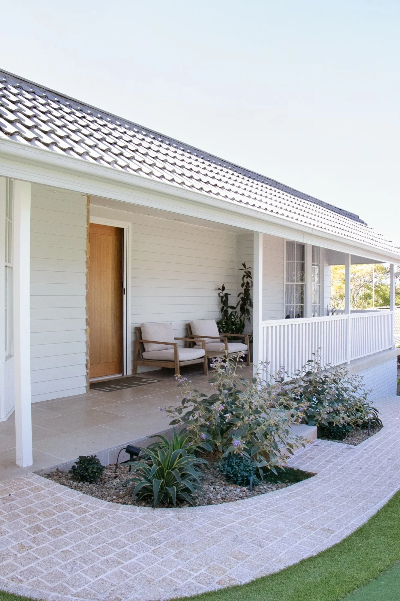 Tiled front patio with outdoor chairs and new planting in Yowie Bay