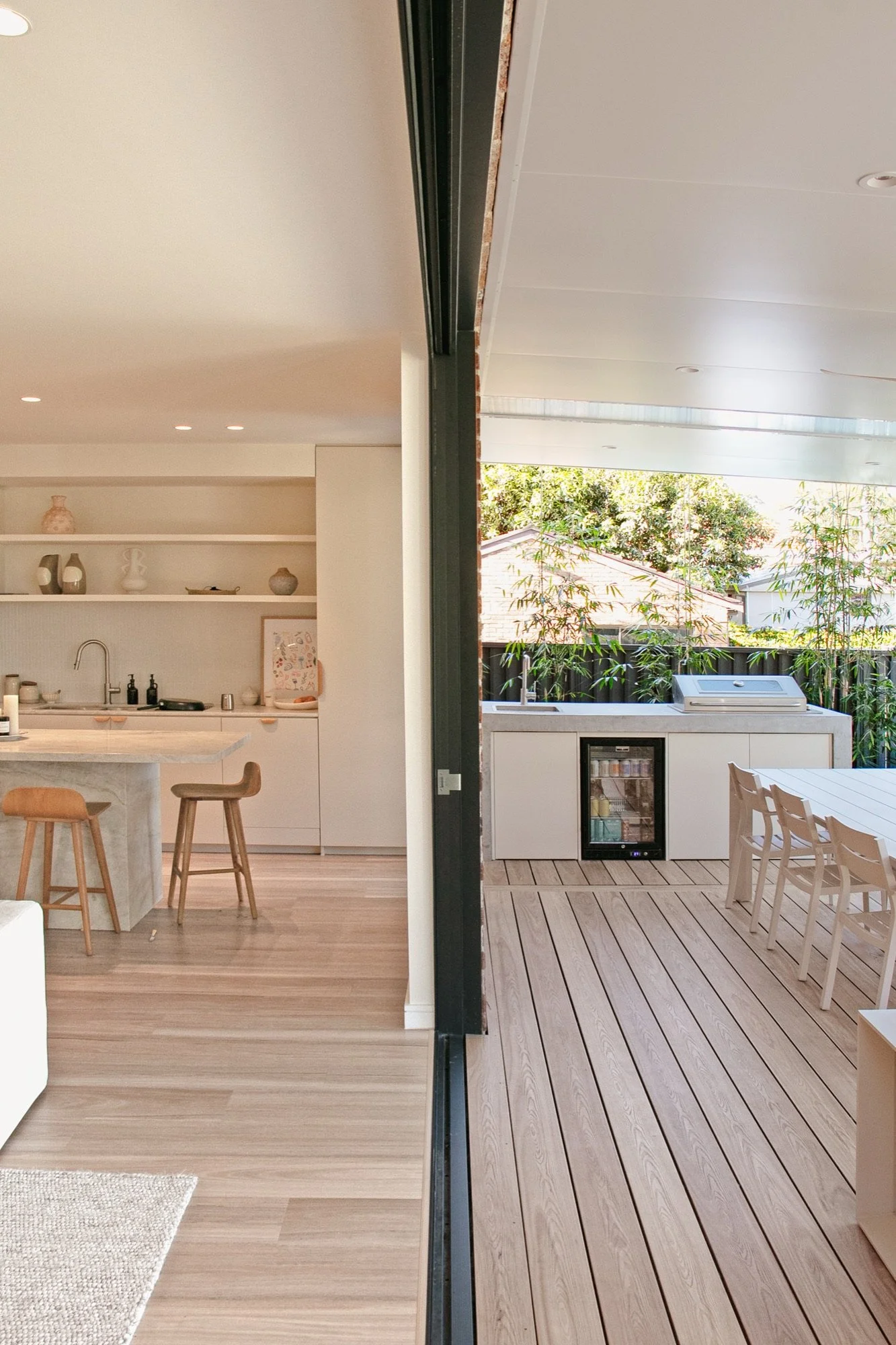 Bifold doors opening from the kitchen to the outdoor kitchen and timber deck in Chifley