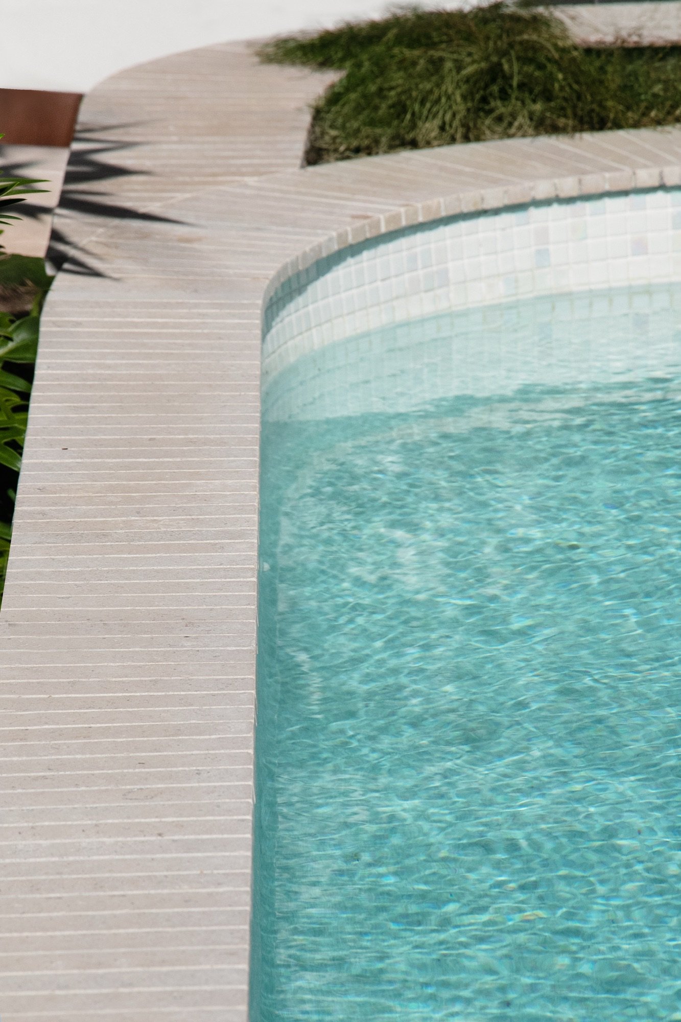 Tiled coping curving around a new concrete pool in Yowie Bay