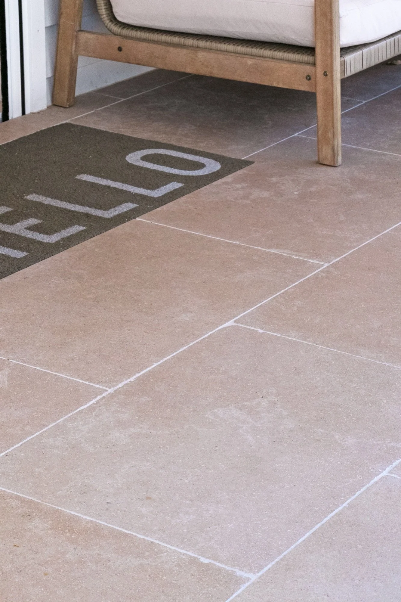 Large-format tiles on a front patio with a welcome mat in Yowie Bay