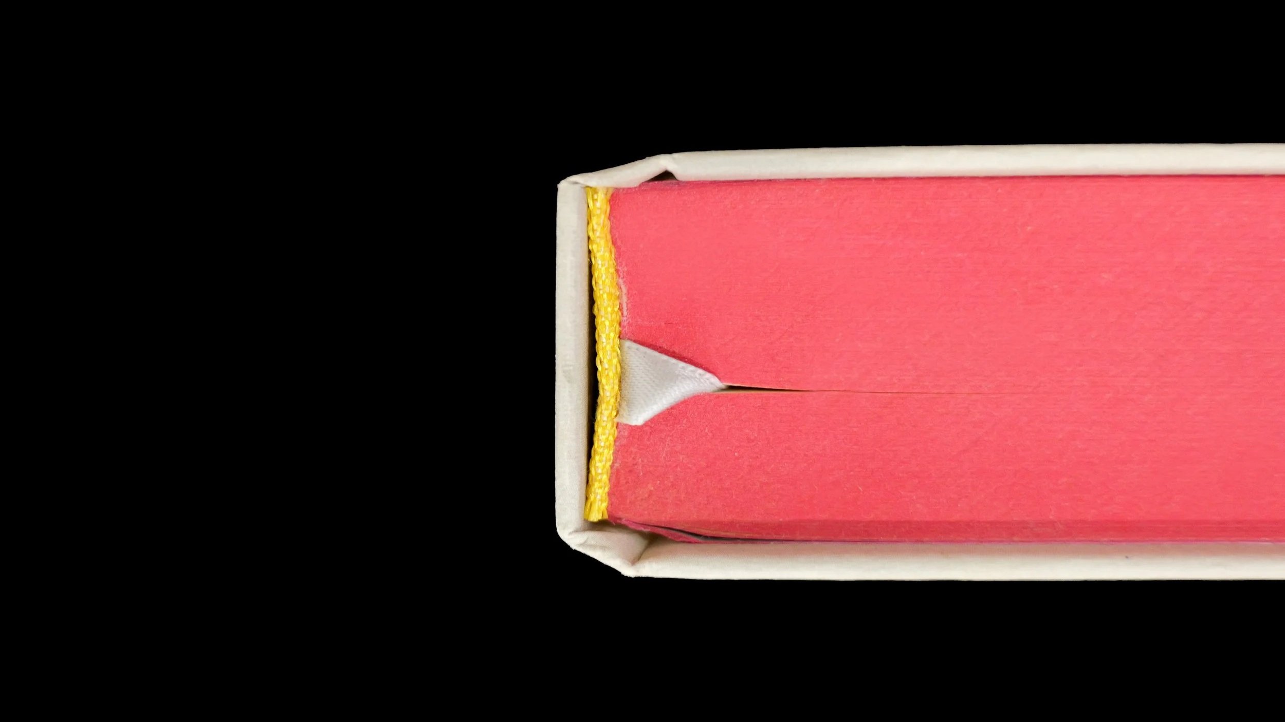 A book with pink paper edges and a yellow head and tail band
