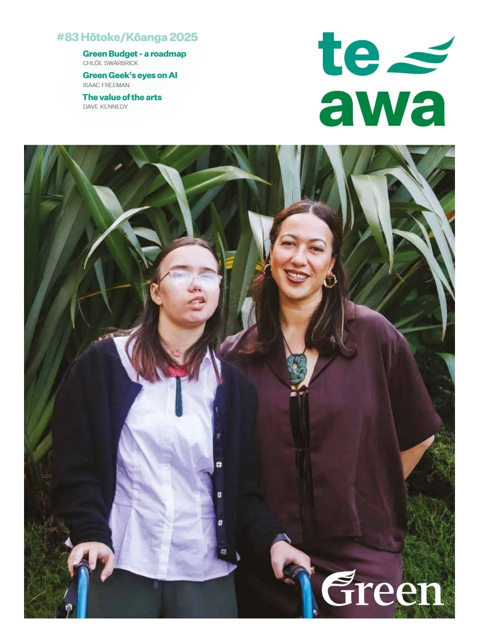 Two women standing in front of green plants, smiling at the camera, one holding a cane.