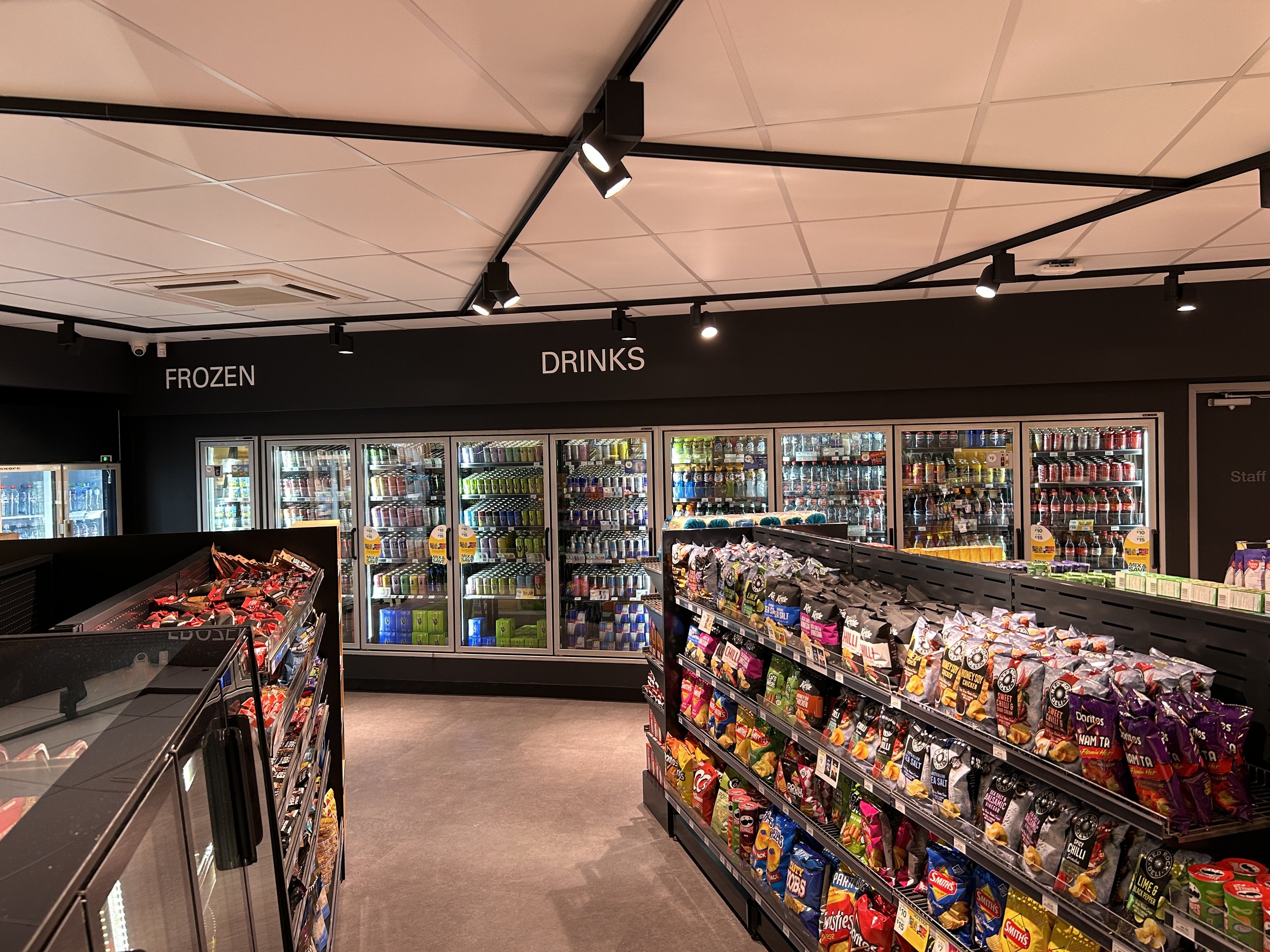 Refrigerated snack and drink section in a convenience store. Glass-door refrigerators