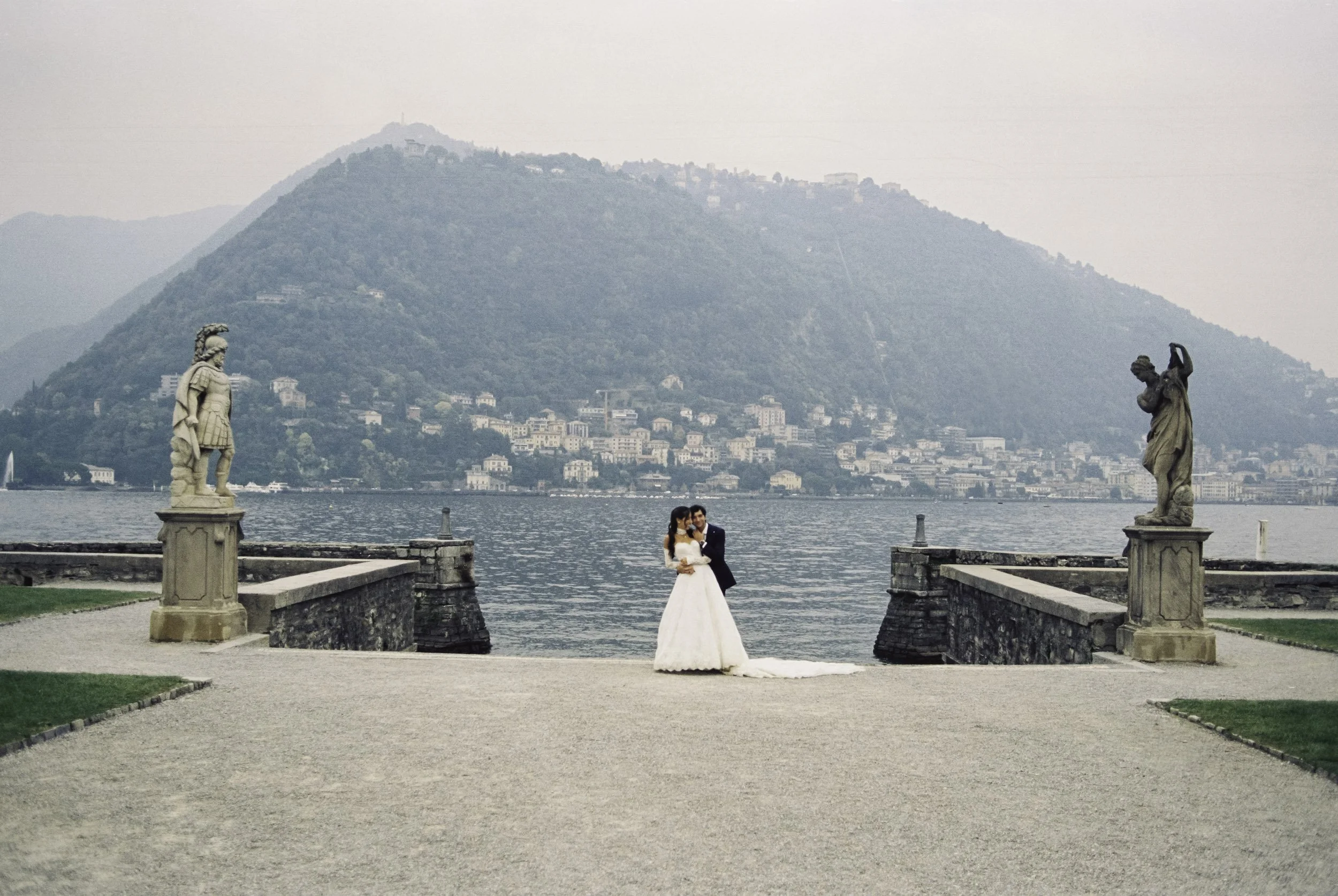 A bride and groom standing on the promenade of Villa Olmo during an analog wedding photography session at Lake Como, Italy.