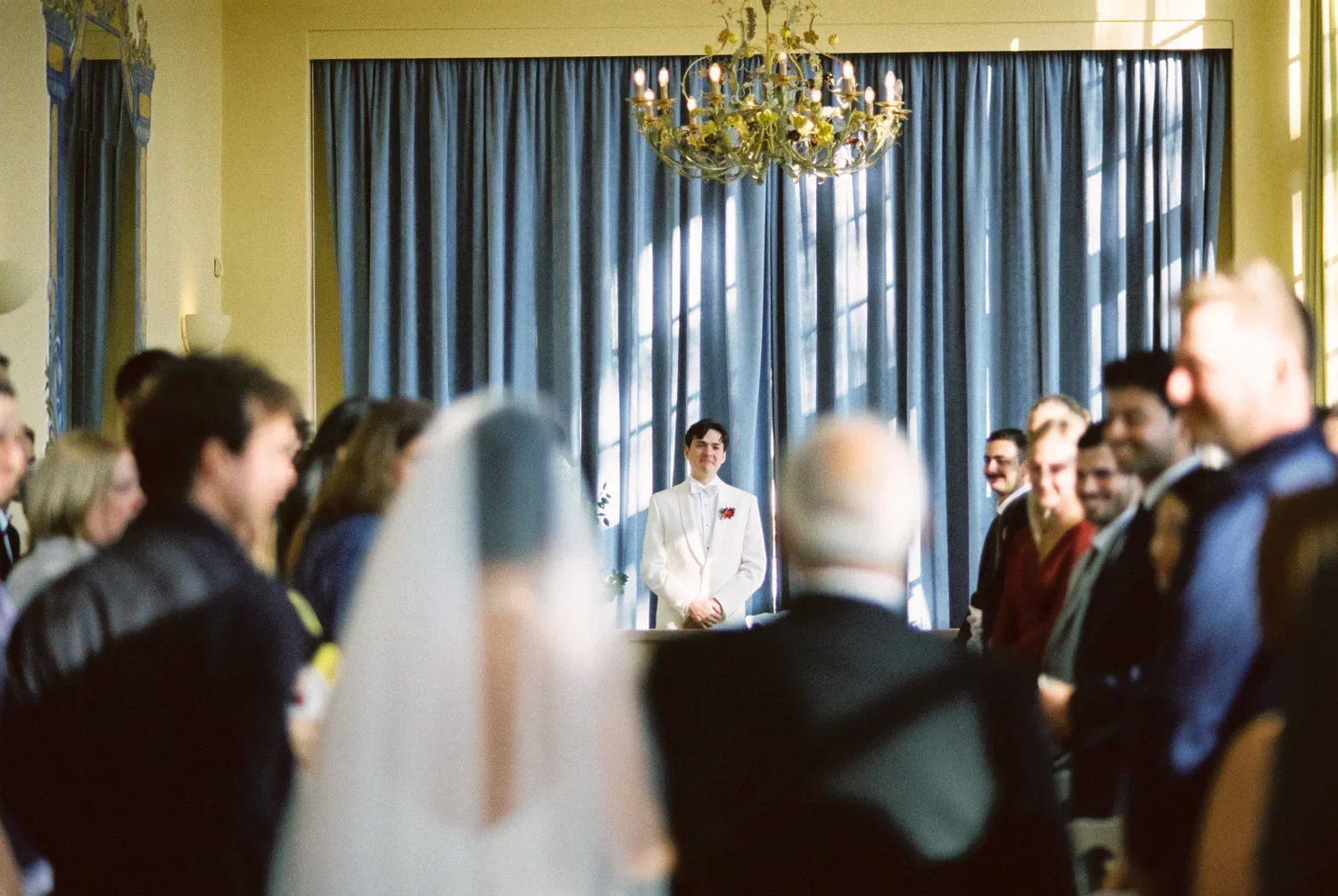 Groom waits at the altar during a ceremony at Schloss Lübbenau, soft analog grain.