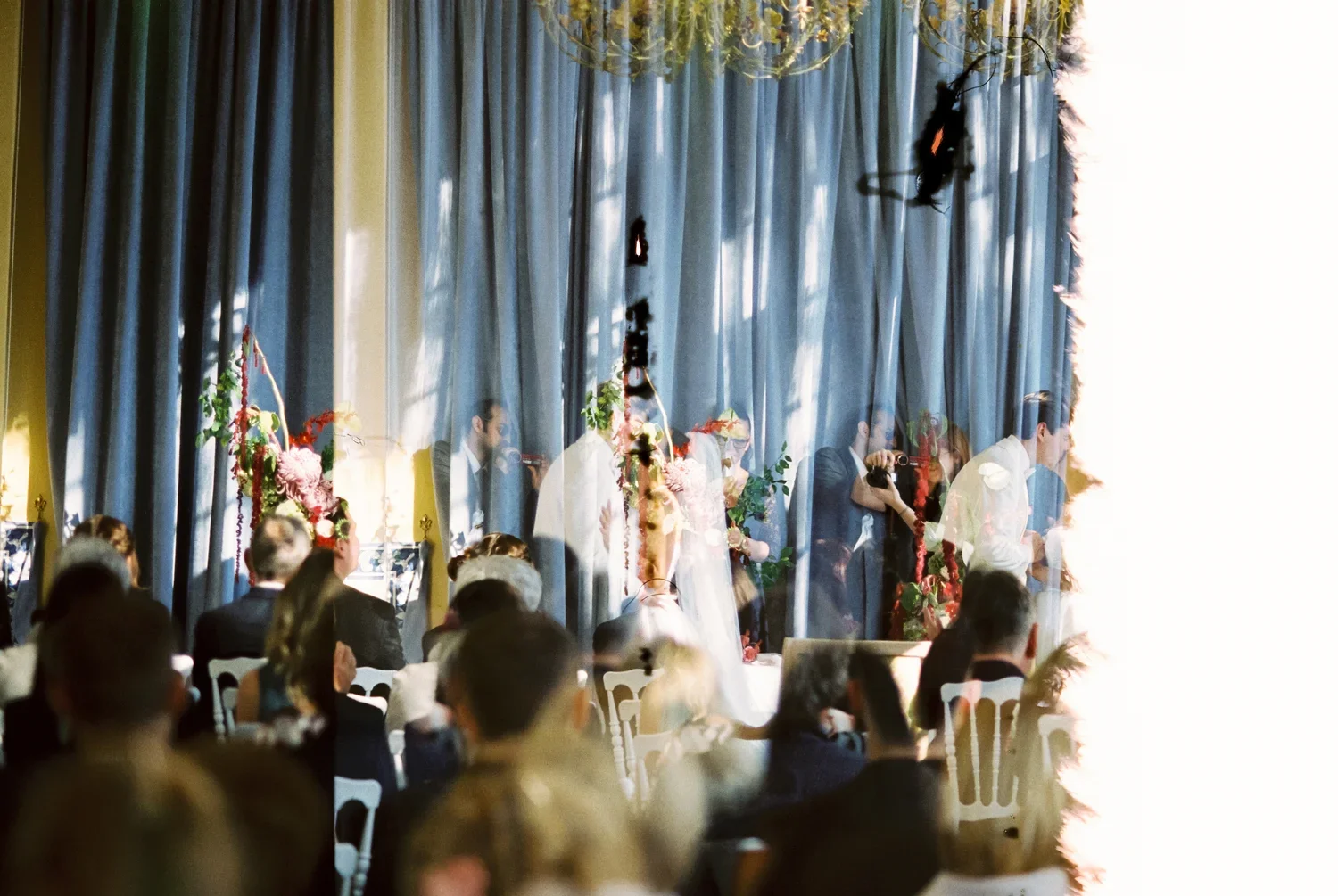 Artistic double exposure and light leak effect during a ceremony, raw analog wedding aesthetic.