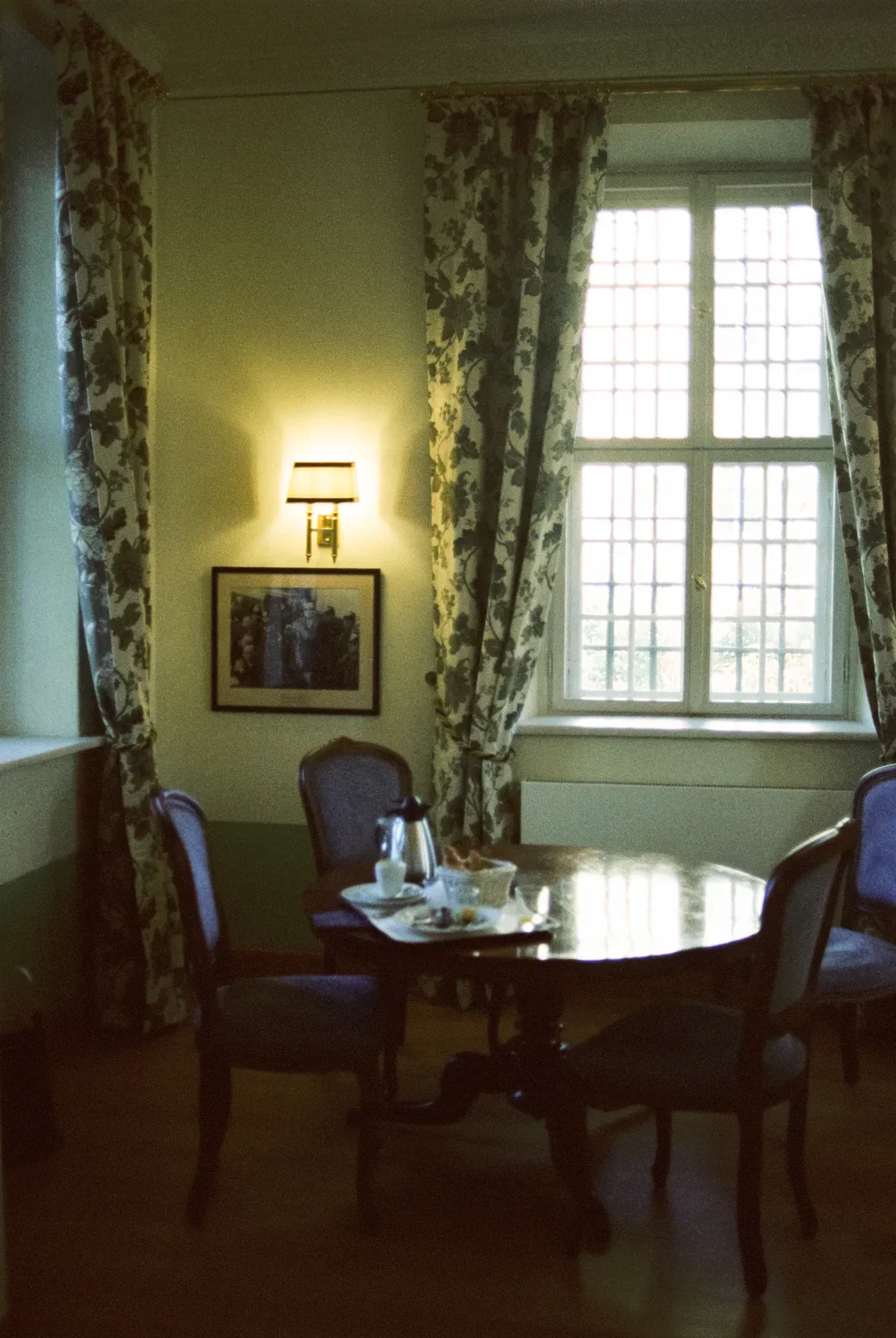 A quiet morning scene with a dining table and floral curtains at Schloss Lübbenau, captured on analog film.