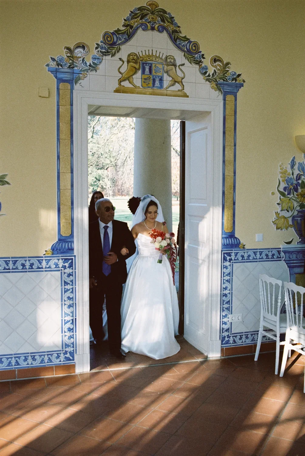 germany-entrance-archway.webp	Bride enters the ceremony hall at Schloss Lübbenau through a classic blue-tiled archway, captured on 35mm film.