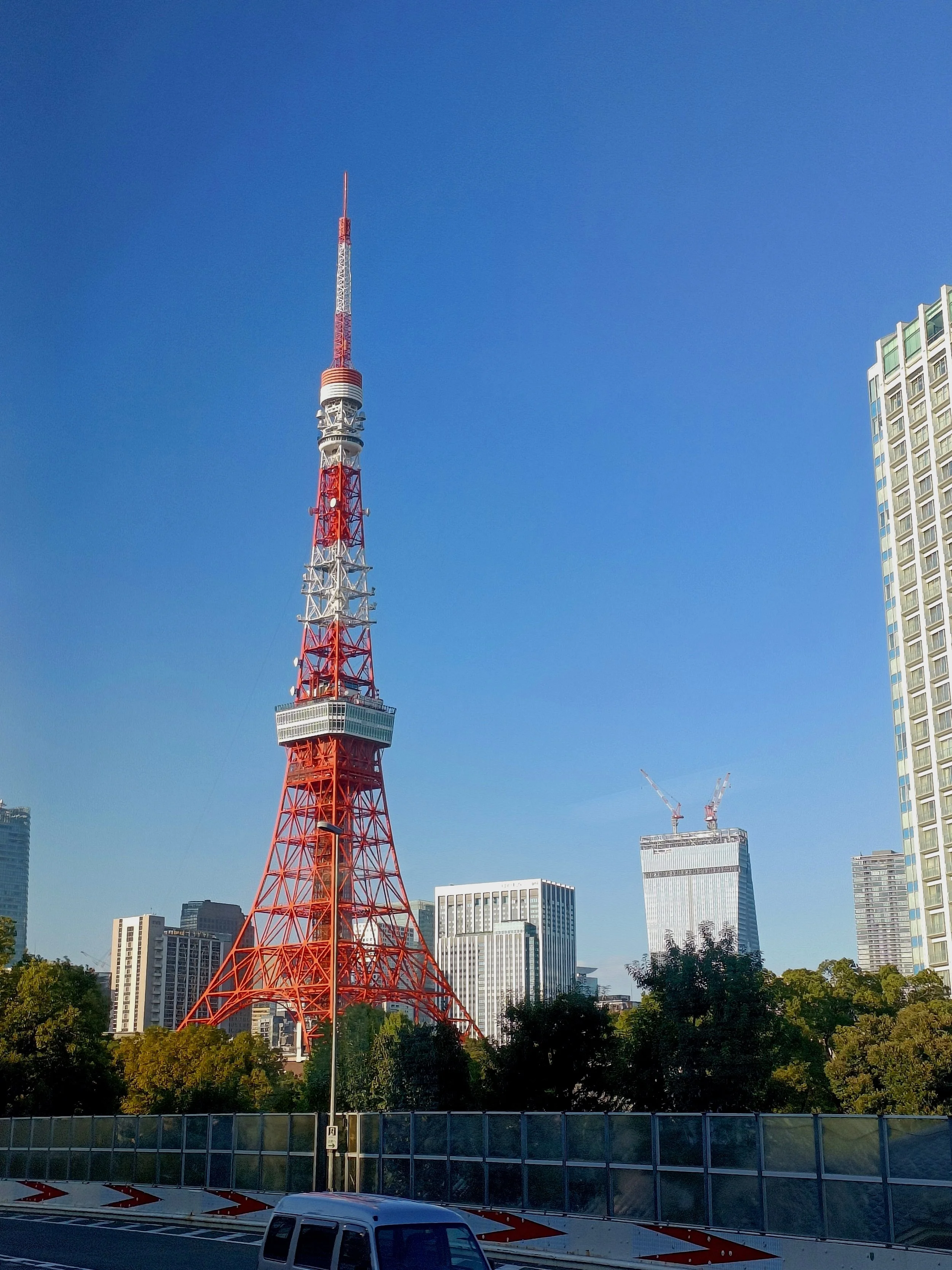 red and white tokyo tower from the outside in the clear sky in the day