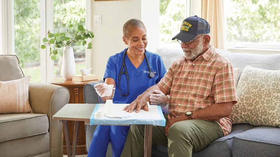 Wound care specialist collaborating with home health nurse to develop treatment plan for patient with complex wound in residential home setting
