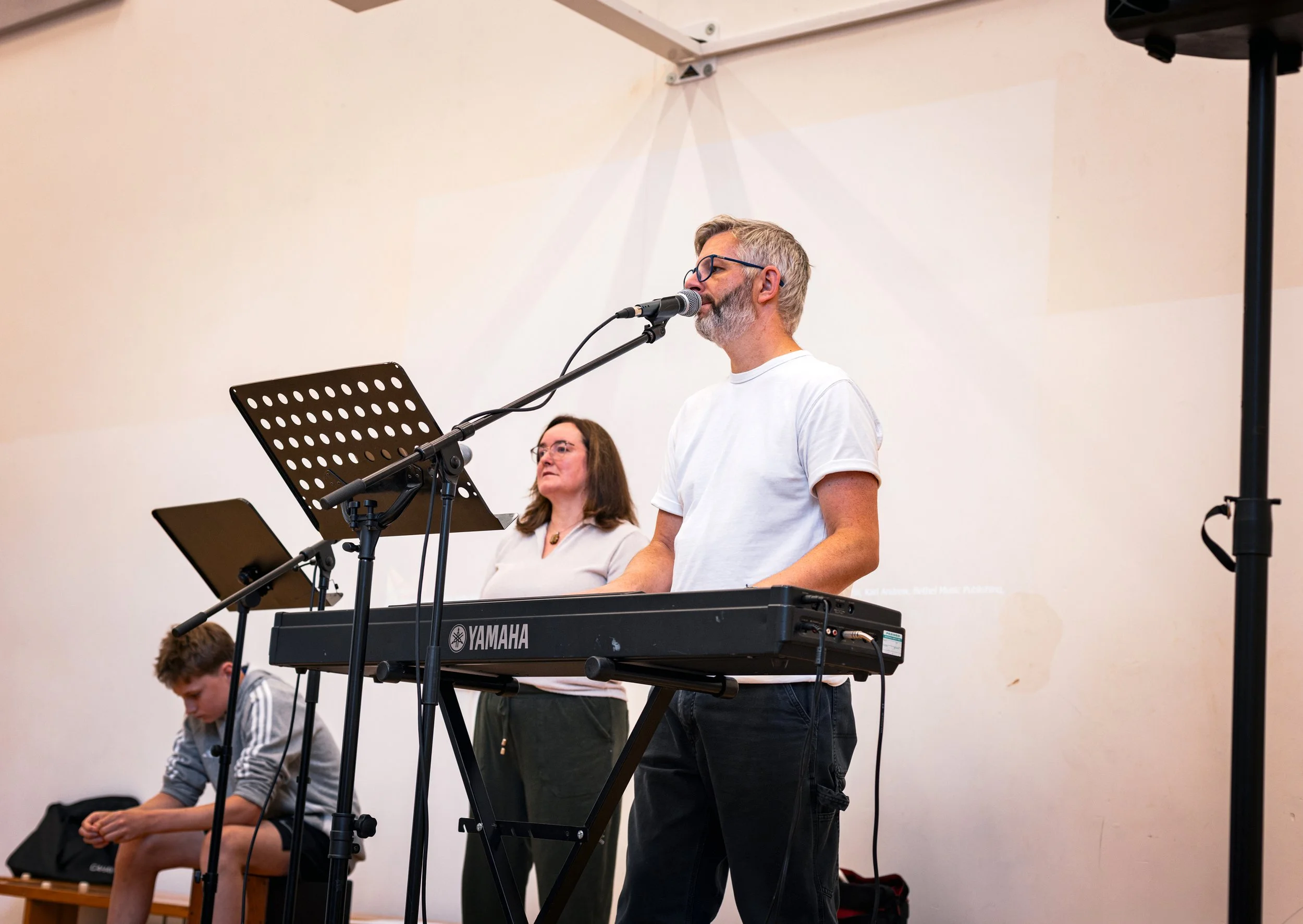 people singing in worship with hands raised