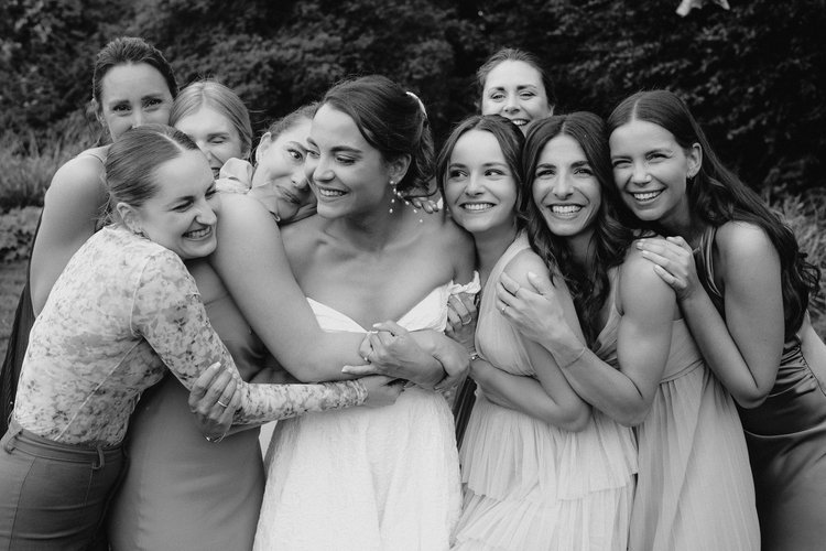 Braut lacht mit ihren Freundinnen bei einer Hochzeit auf Gut Ostenwalde