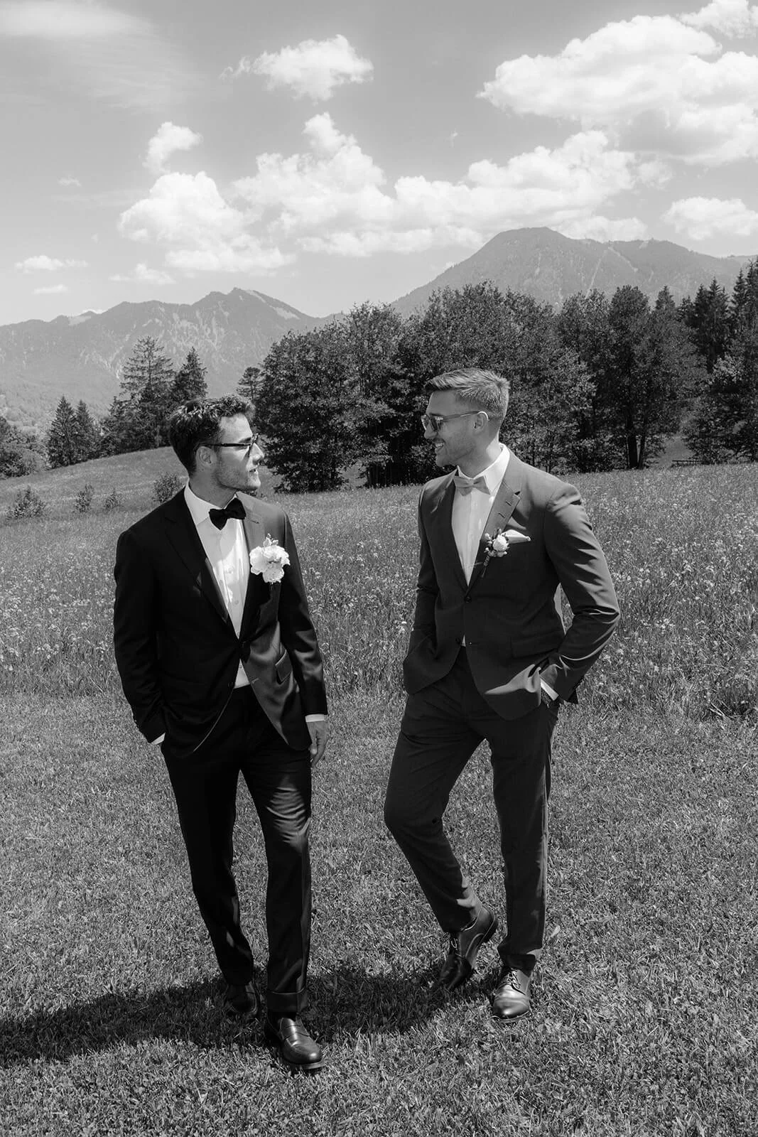 Groom and best man in tuxedos chatting outdoors before the ceremony..jpg