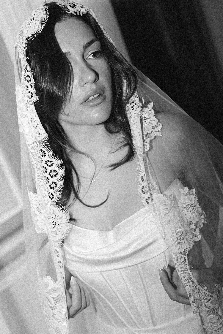 Bride in a lace veil looking to the side, black and white