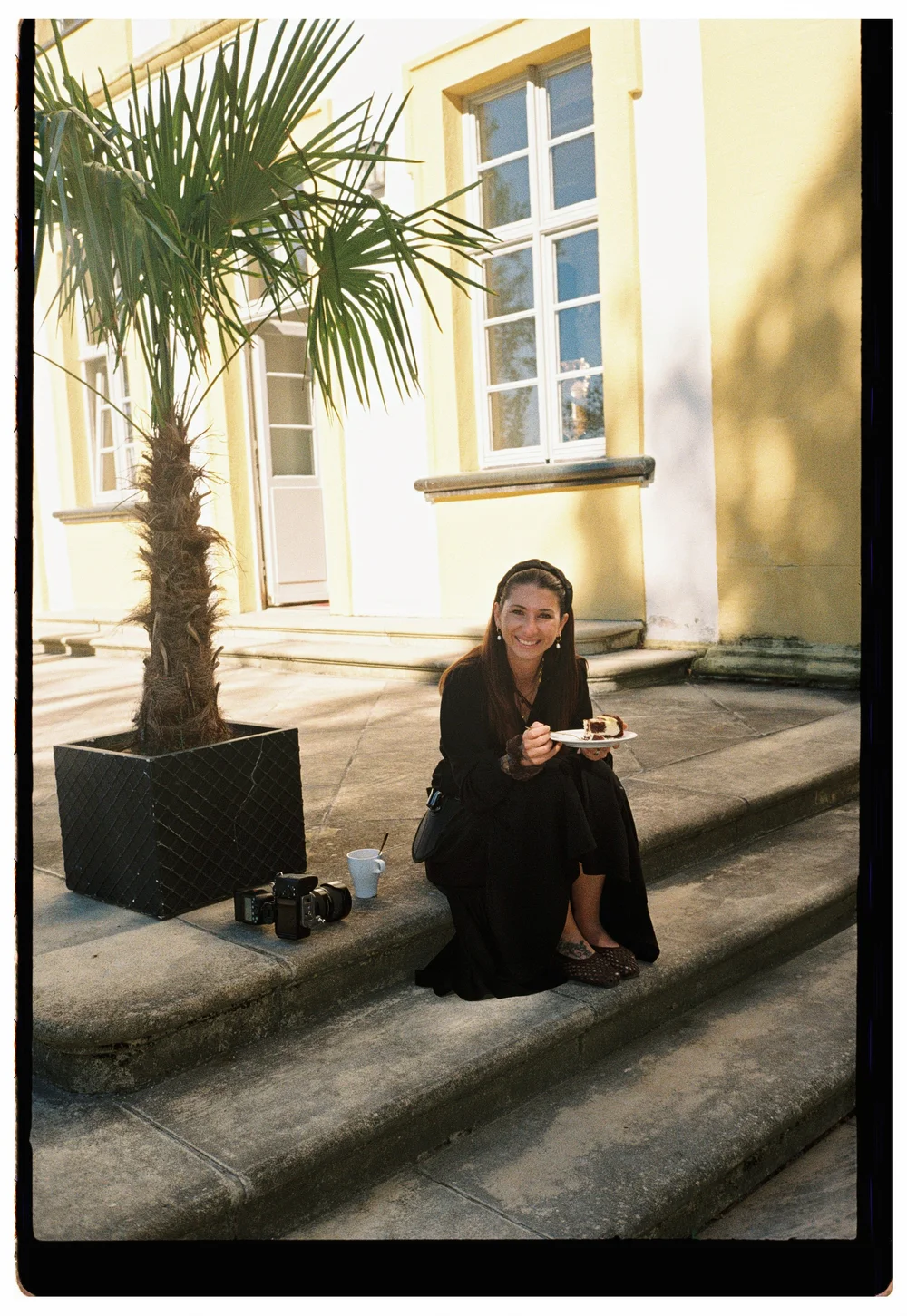 Jenni Biddle sitting on sunlit steps with her camera