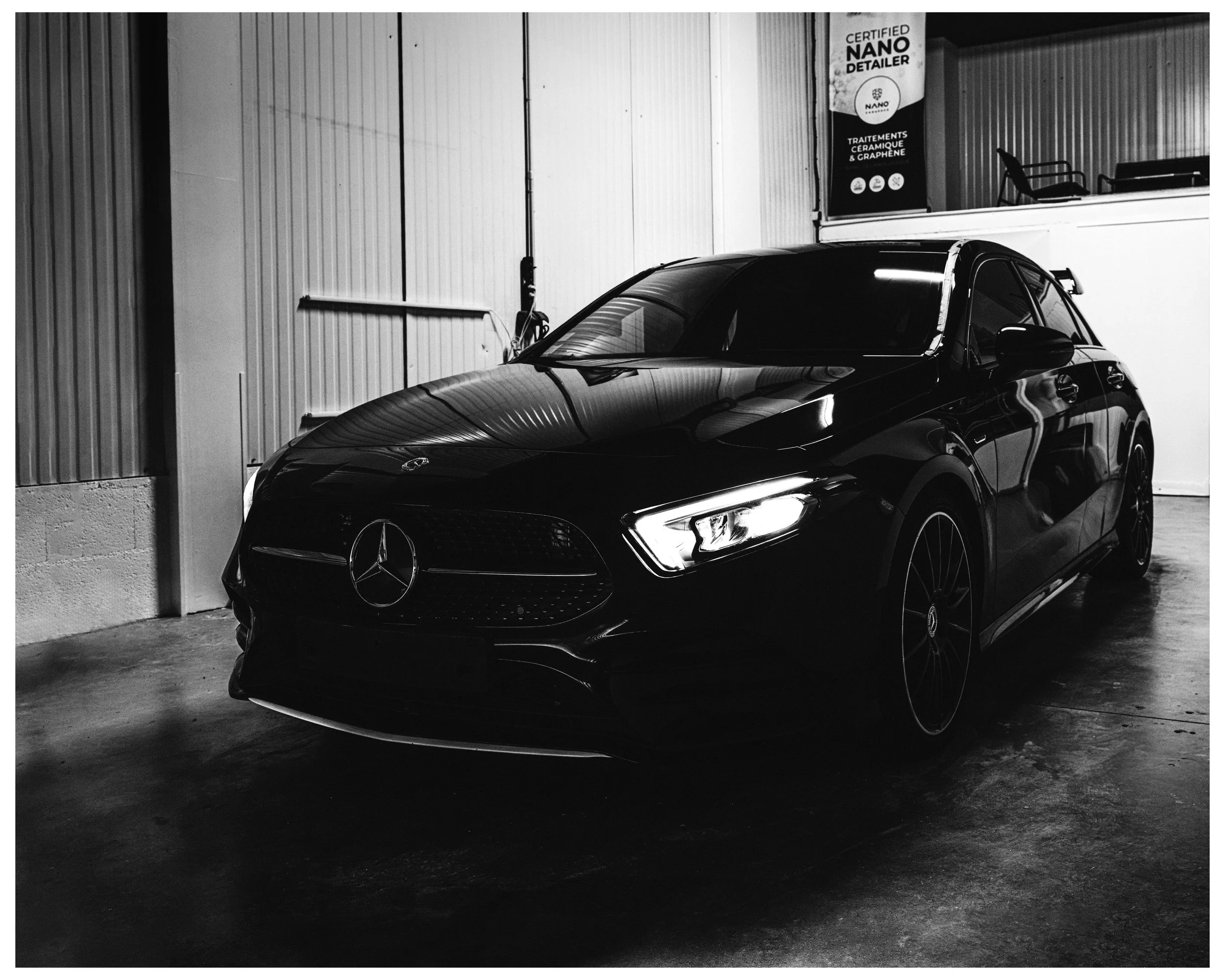 Voiture Mercedes noire dans un garage, vue frontale gauche