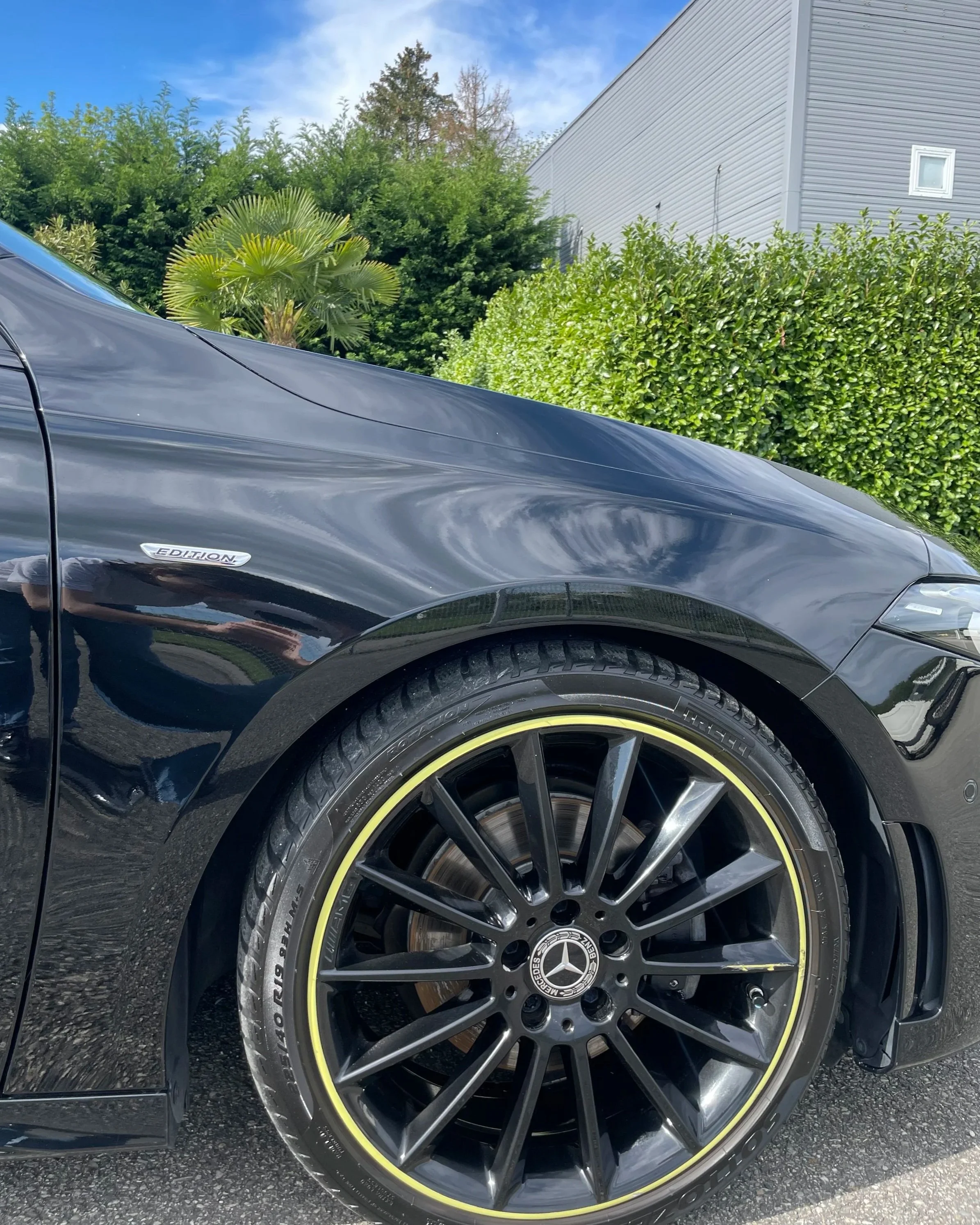 Voiture noire de sport Mercedes-Benz avec un badge Edition, vue de côté, avec un autre pneu et jantes, en extérieur sous un ciel bleu.