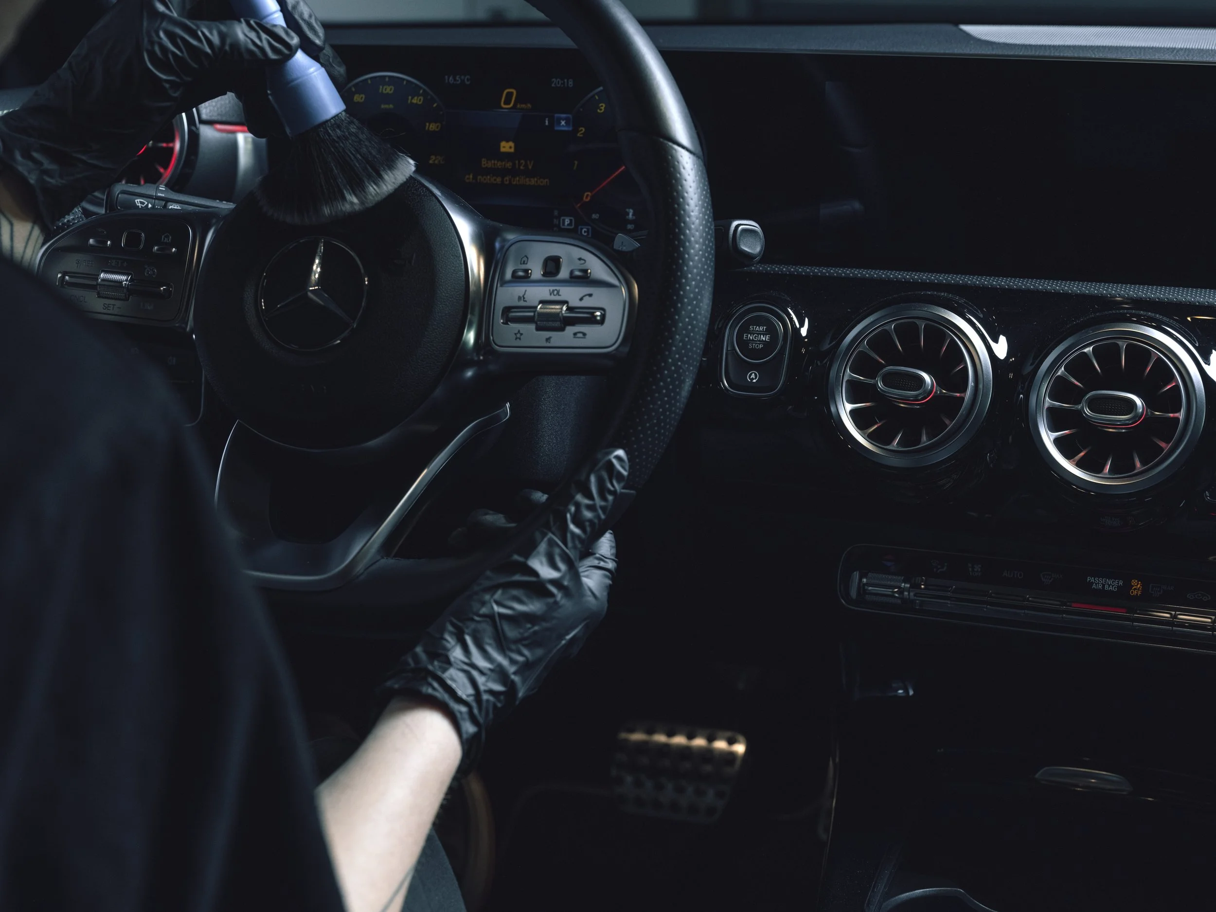 Intérieur d'une voiture Mercedes-Benz avec un volant, des commandes et un tableau de bord modernes.