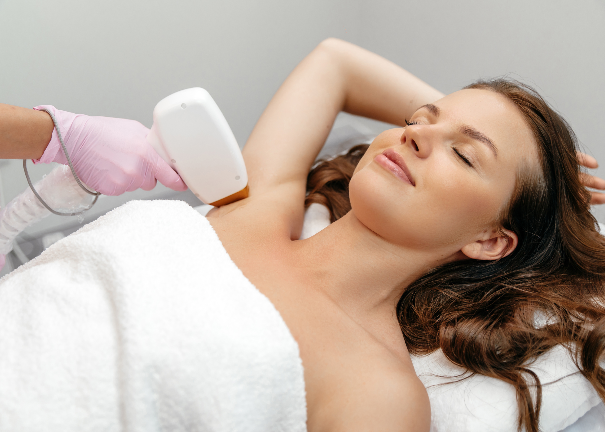 A woman getting laser hair removal done on her armpits.