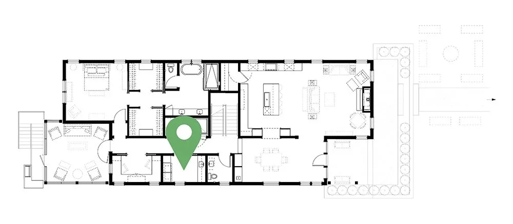 Floor plan of a house with multiple rooms, including living areas, bedrooms, bathrooms, kitchen, and outdoor space, with a green location marker.