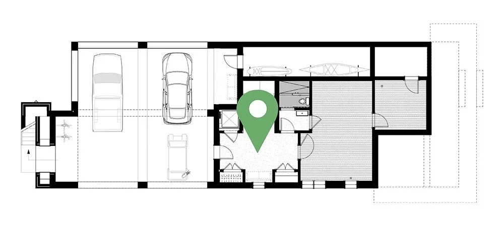 Floor plan of a house showing a garage, living spaces, bedrooms, and outdoor areas with a green location marker in the center.