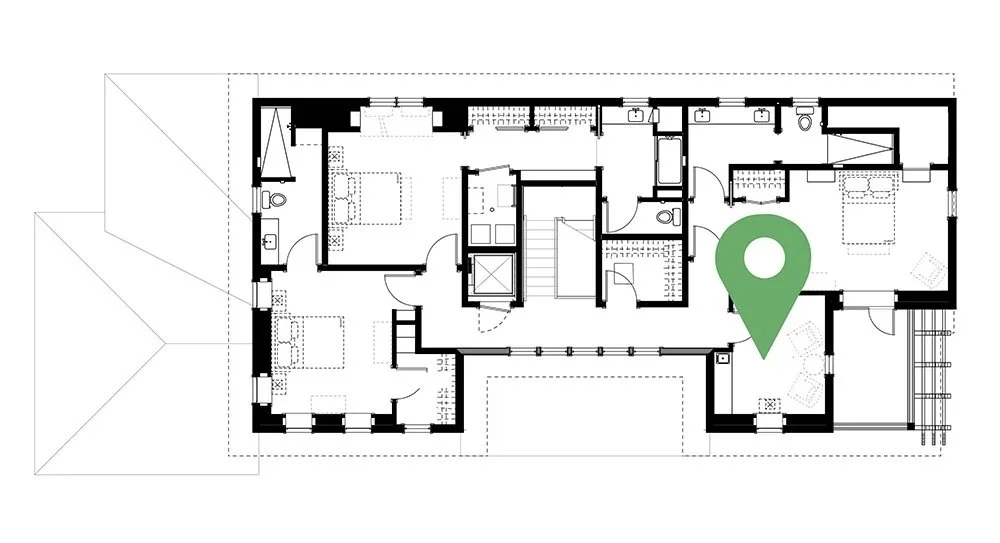 Floor plan of a building with rooms, stairs, and a green location marker.