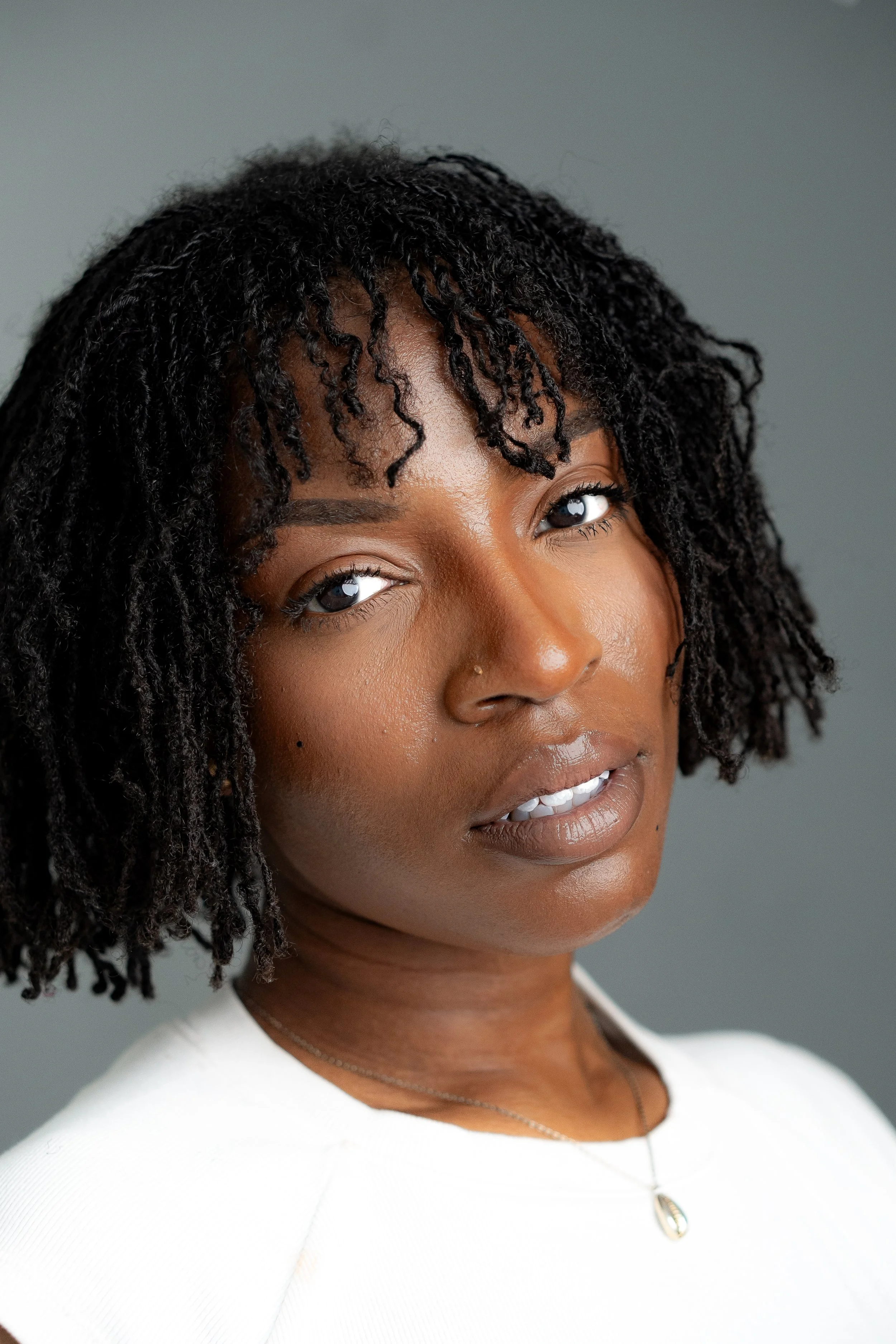 African American Woman with Short locs Actor Character Headshot grey Background ..jpg