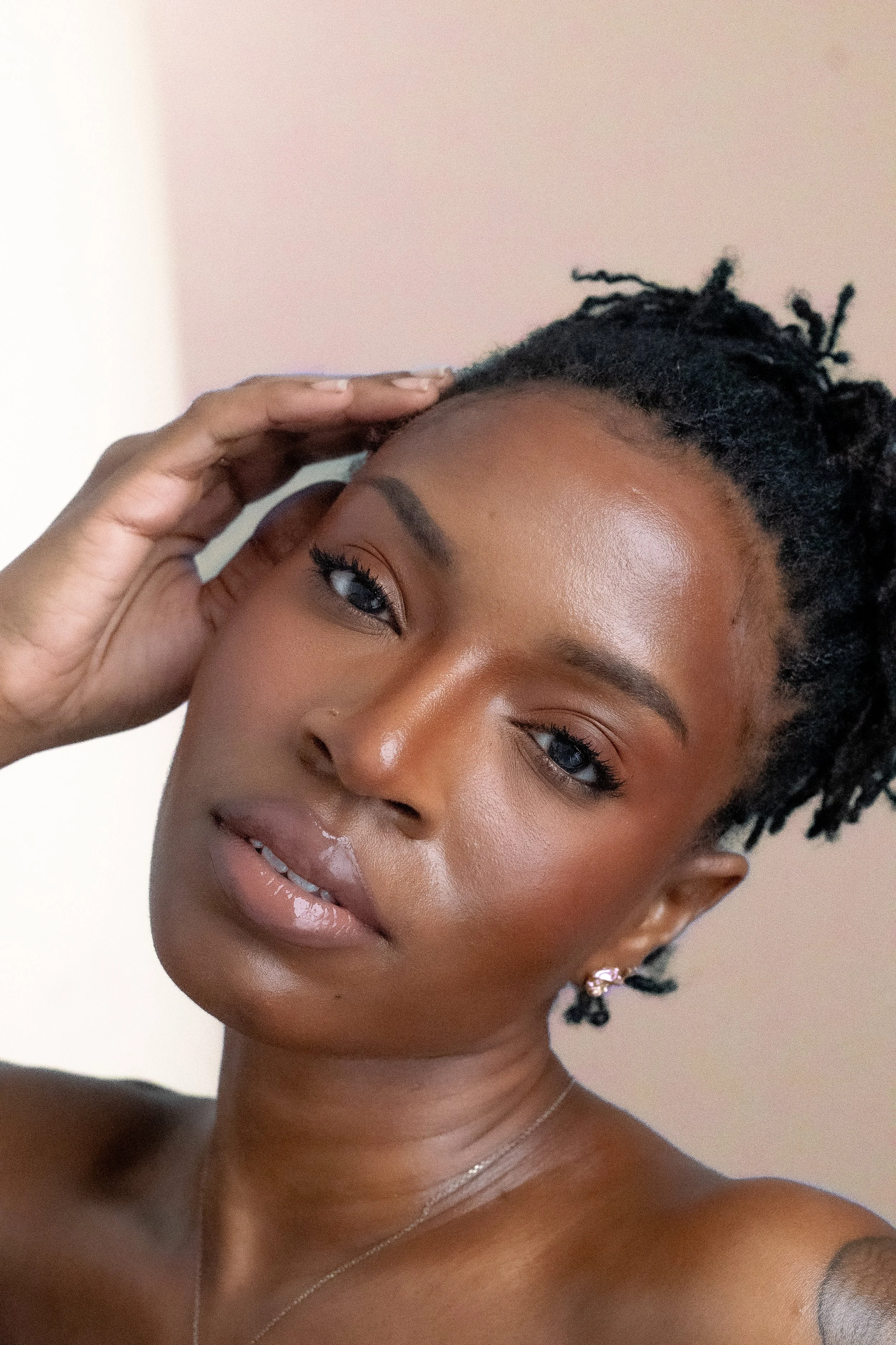 Woman with locs beauty shot peach background 1.jpg