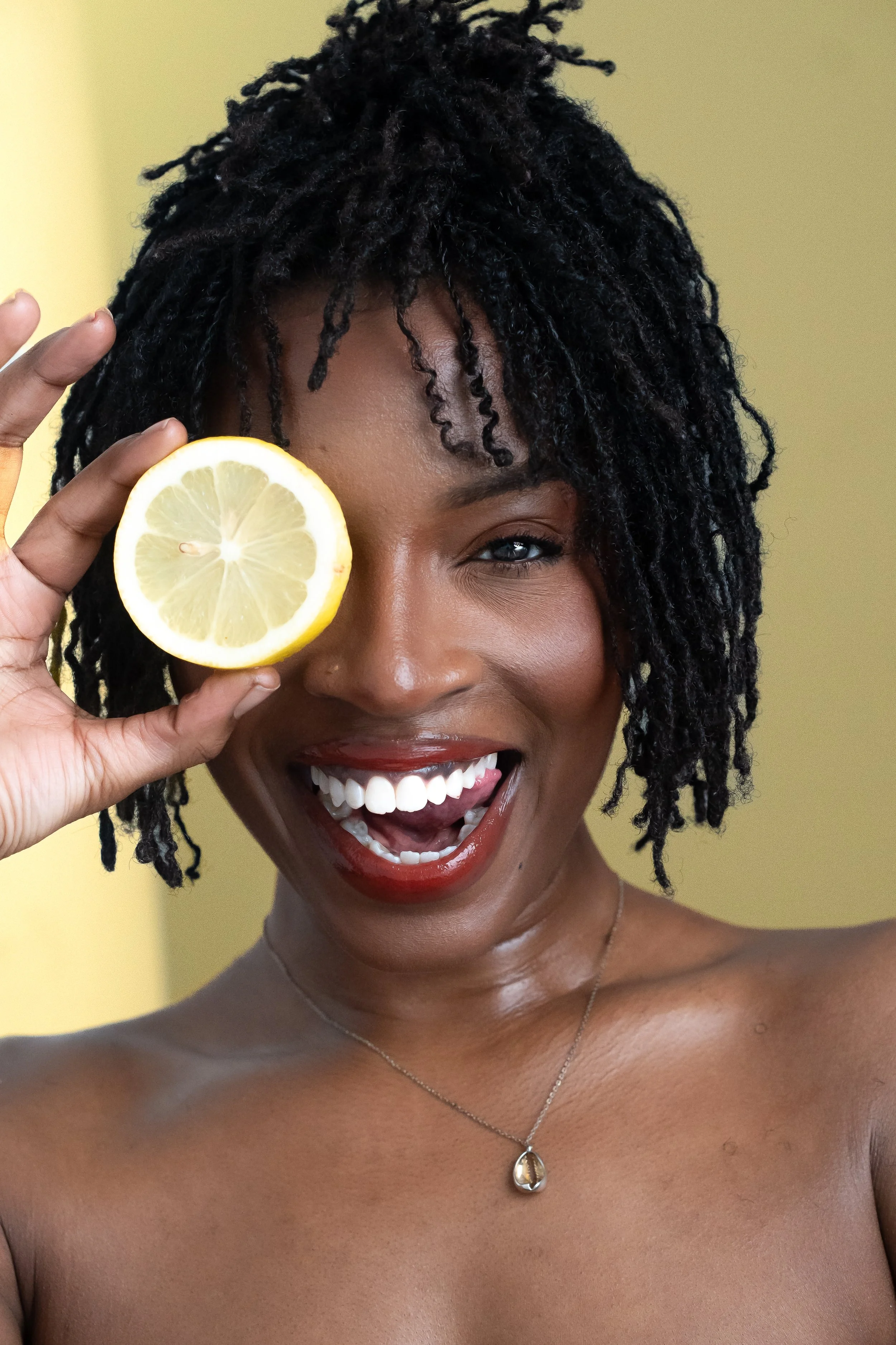 African American women with loc Updo Lemon slice and red lip smiling Beauty shot.jpg