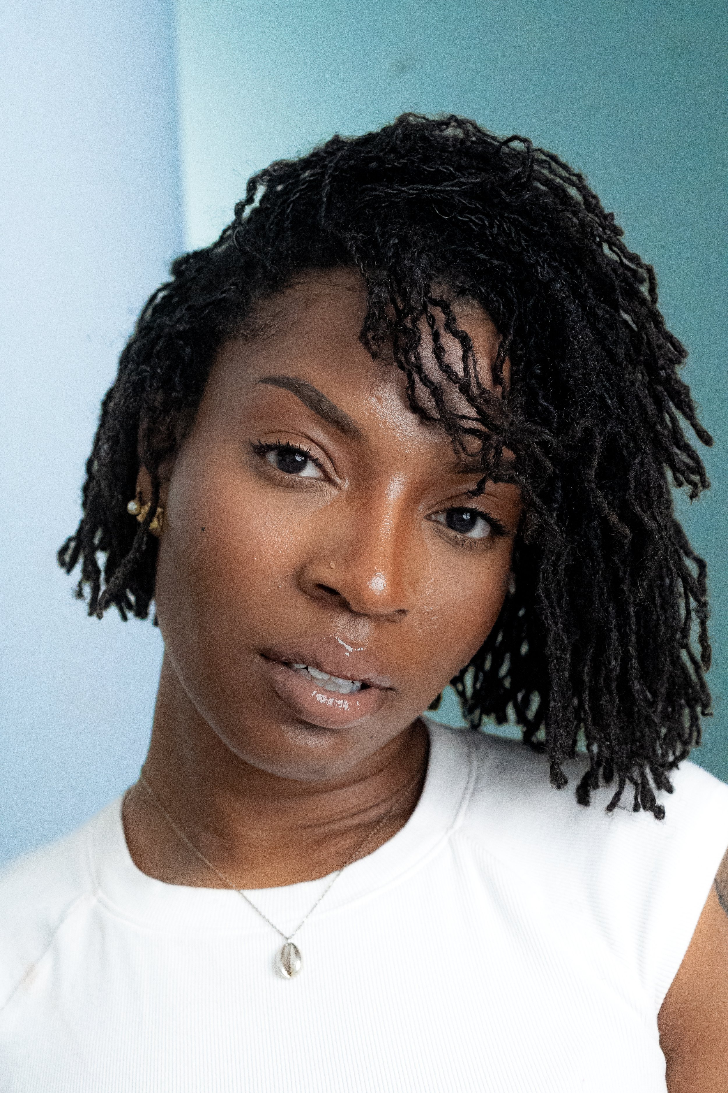 African American Woman with Short locs Actor Moody Headshot blue Background 2.jpg