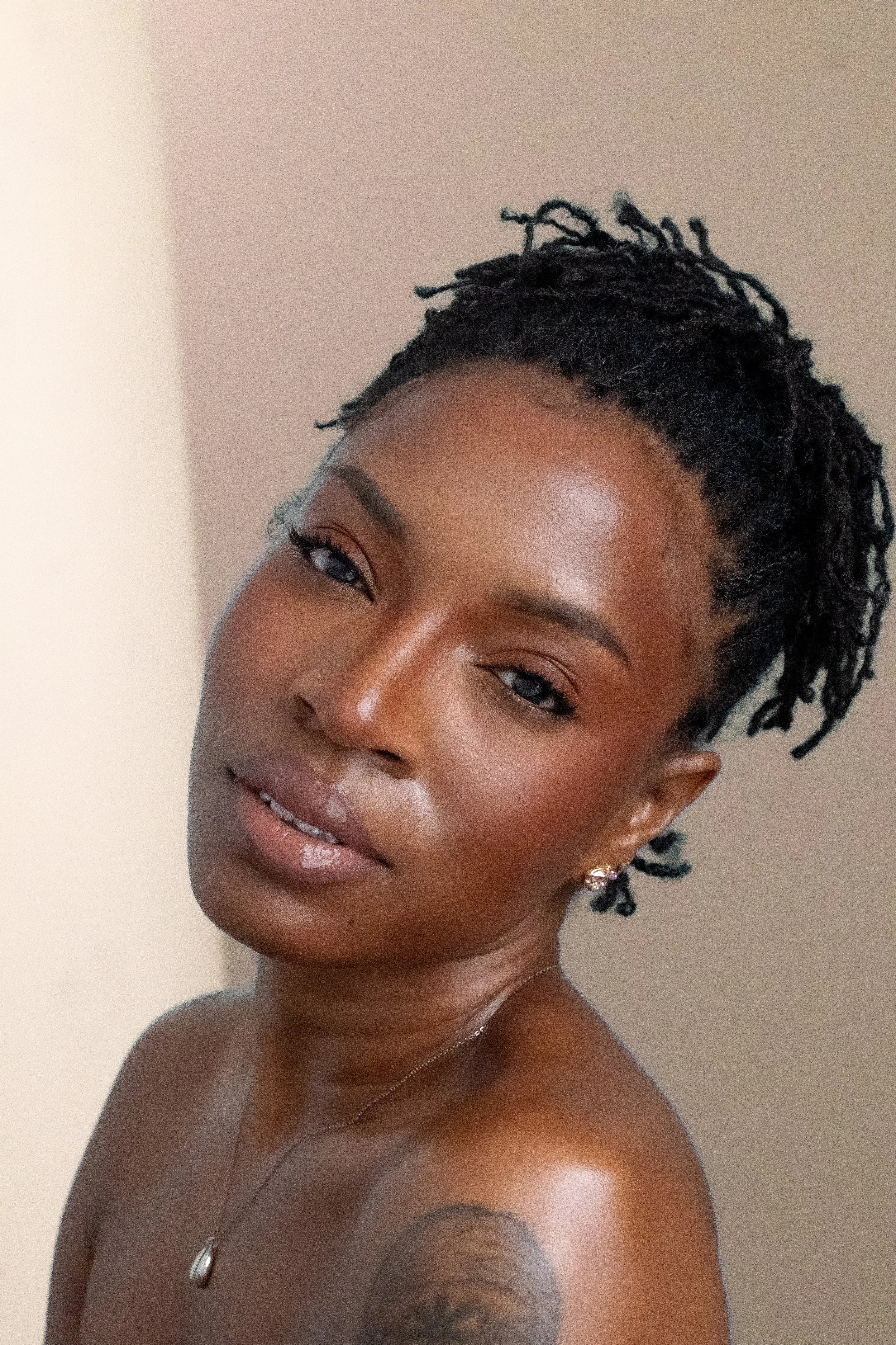 Woman with locs beauty shot tan background.jpg
