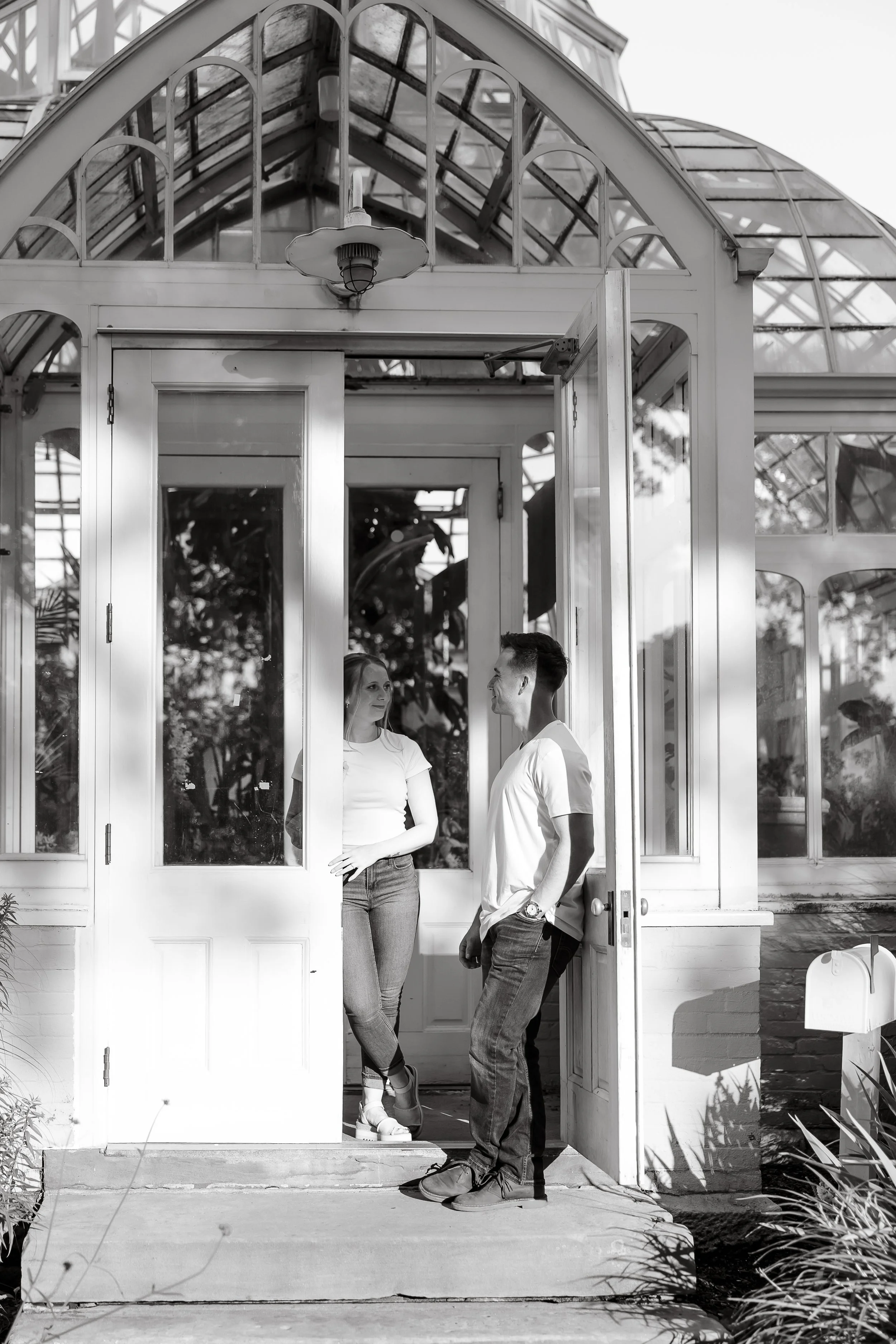 Engaged couple embraces in a doorway during a Pittsburgh engagement session, black and white documentary photo