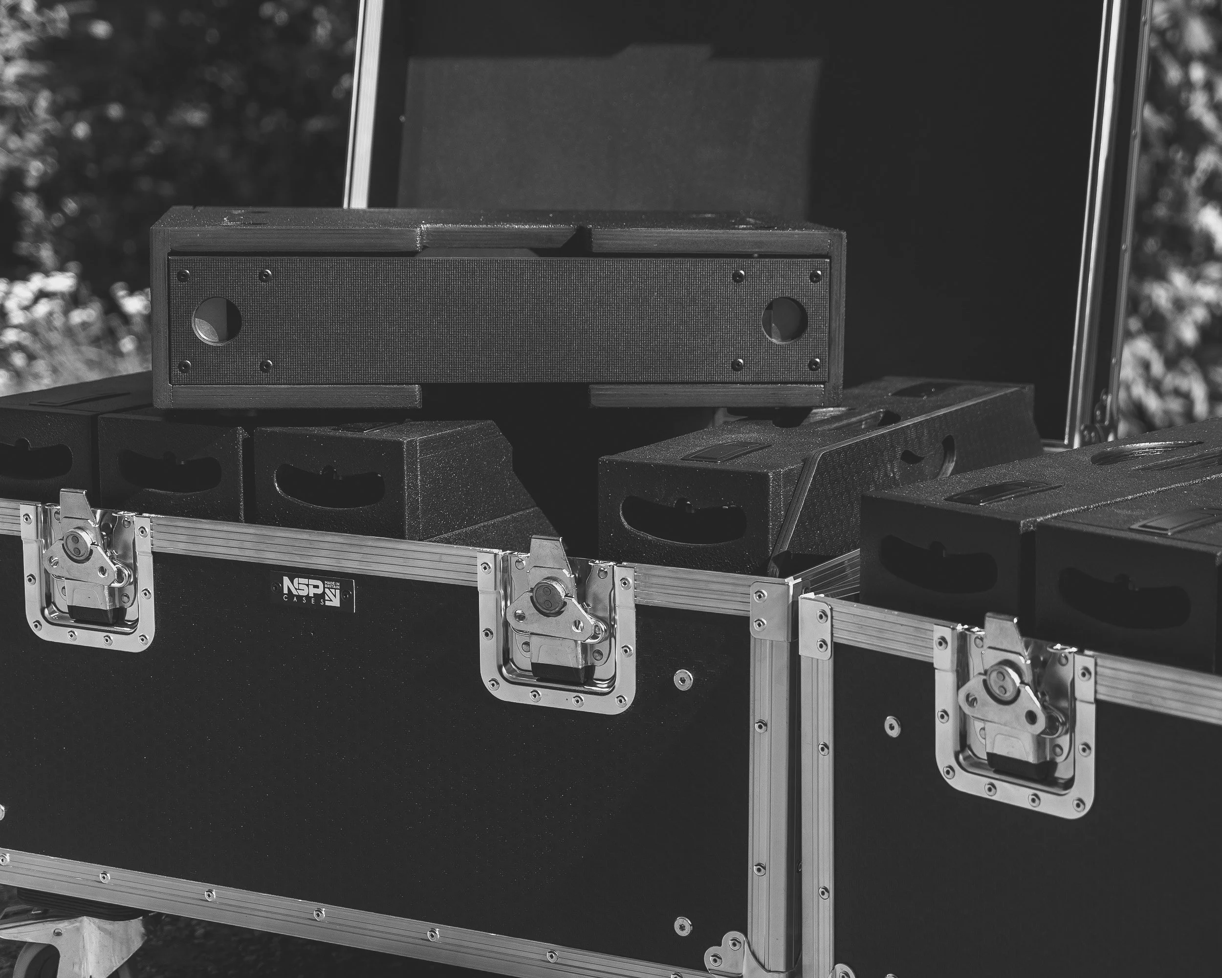 A wooden rack sleeve on top of a flight case which holds multiple rack sleeves.