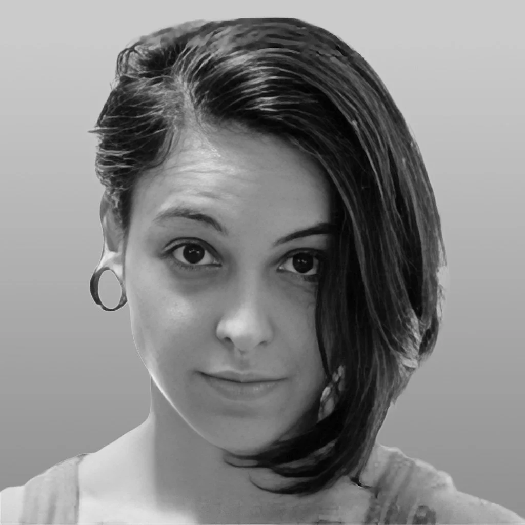 Black and white portrait of a woman with short, asymmetrical hair, one side longer and swept to the side, wearing hoop earrings, with a subtle smile.