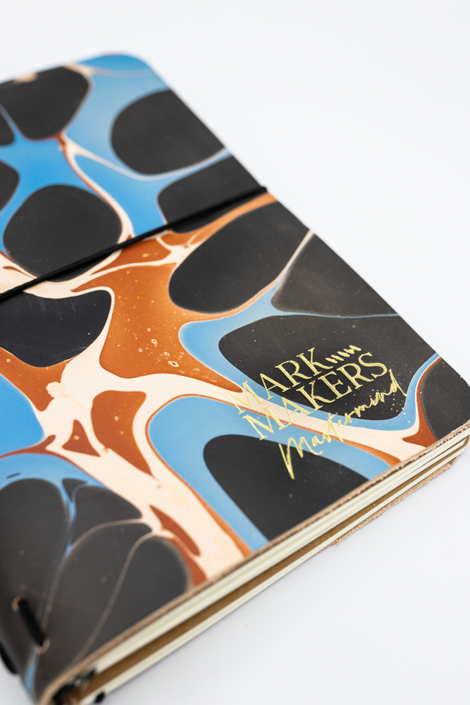 Colorful notebook cover with abstract marbled design and custom stamp.