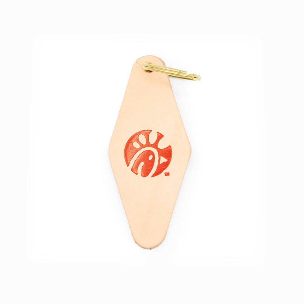A beige leather keychain with a red logo and a gold metal ring.