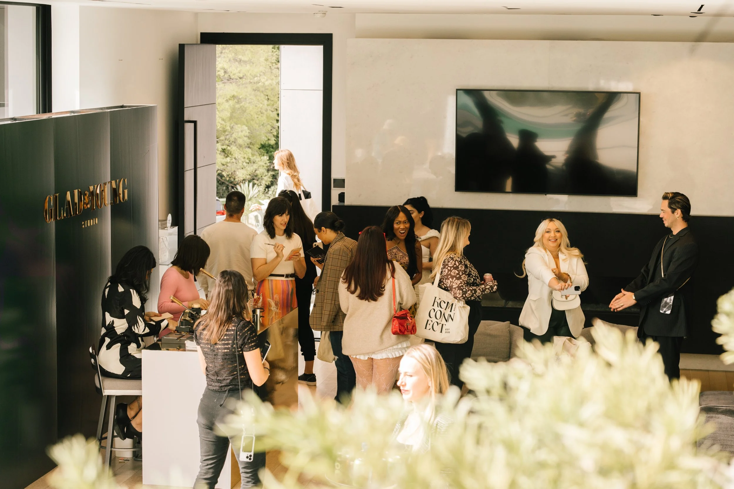 A group of people socializing at an indoor event, with various individuals talking and holding beverages. 