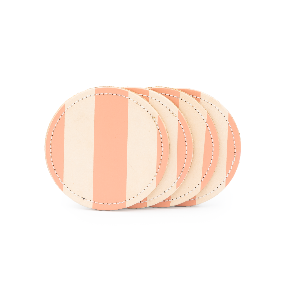 Four round leather coasters with alternating peach and beige stripes stacked on a white background.
