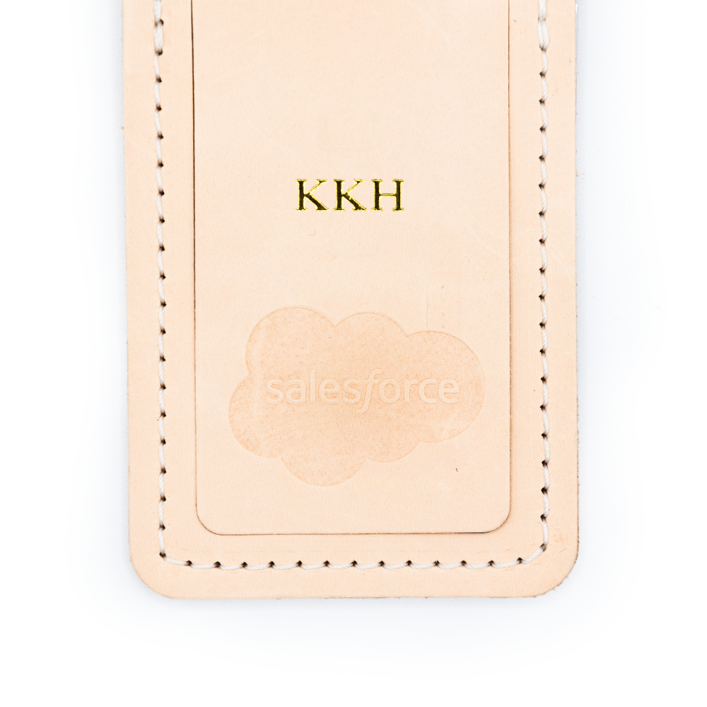 Leather tag with initials "KKH" and embossed Salesforce cloud logo.