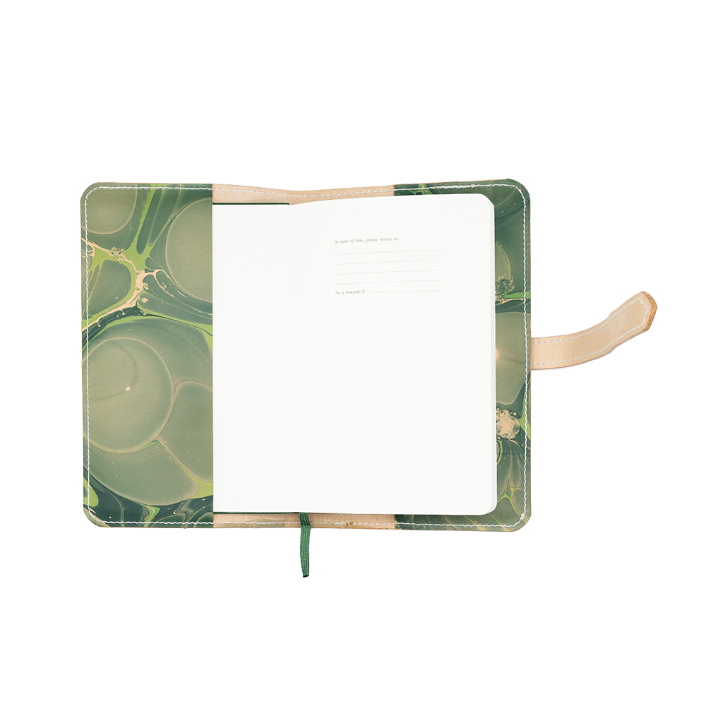 Open notebook with green marbled cover and leather strap