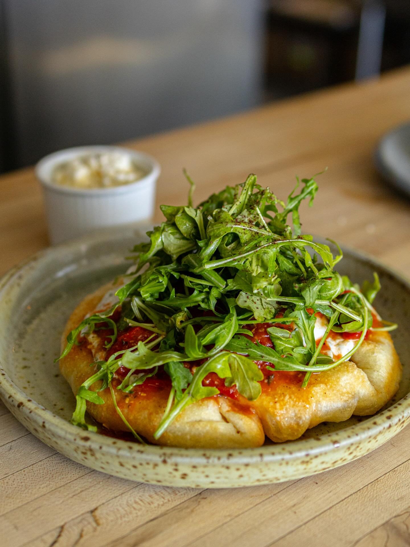 Have you had Wildroots take on a Shakshouka yet? 

Our beautiful pizza dough fried is the base of this delicious breakfast with a roasted red pepper and tomato chutney with a herby riata dollop on top. Then it has a poached eggs, feta cheese and  an 