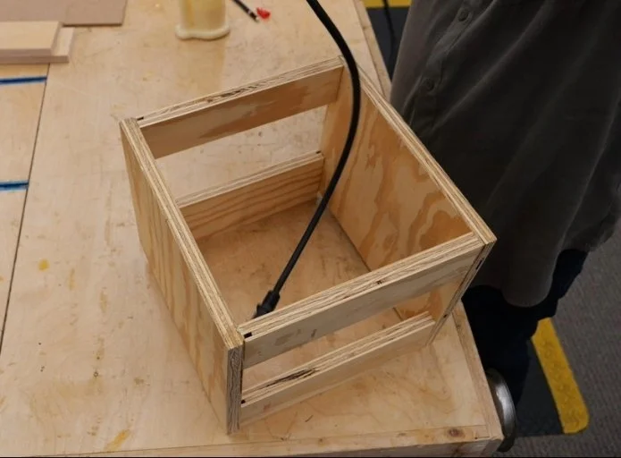 a router table made of two side panels and four rails, sitting on top of a wooden workbench